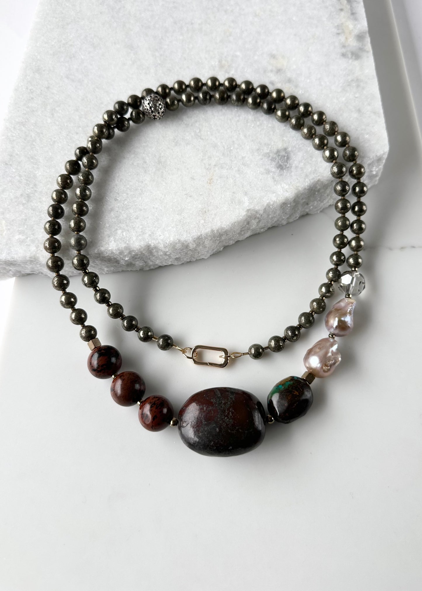 This Unique Long (40”) Necklace Features a combination of Brown Turquoise, Mahogany Obsidian, Pyrite, Crystal, Baroque Freshwater Pearls, finished with Silver and Gold Accents and a Charm Clasp. Wear it Long or Double it up!