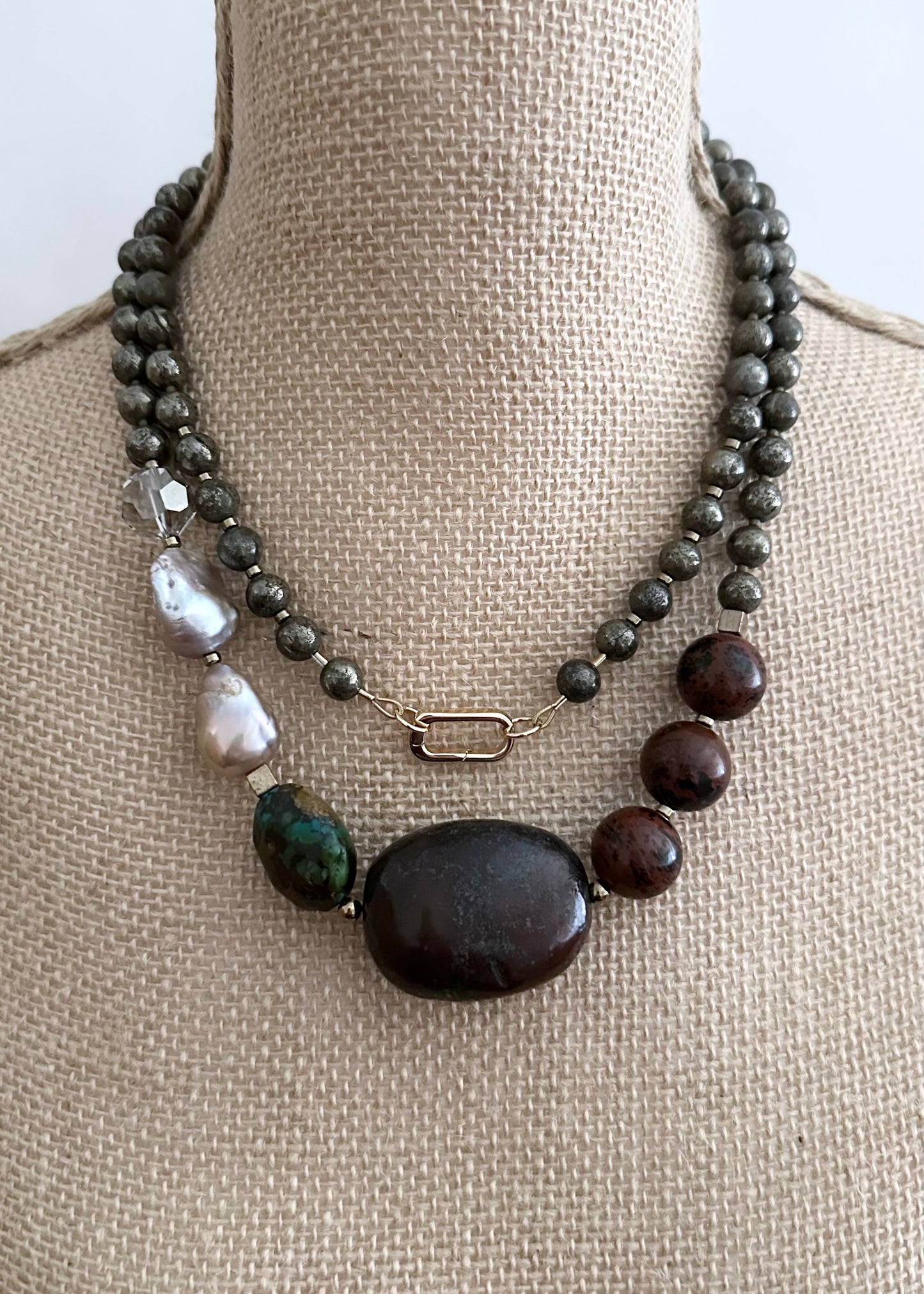 This Unique Long (40”) Necklace Features a combination of Brown Turquoise, Mahogany Obsidian, Pyrite, Crystal, Baroque Freshwater Pearls, finished with Silver and Gold Accents and a Charm Clasp. Wear it Long or Double it up!