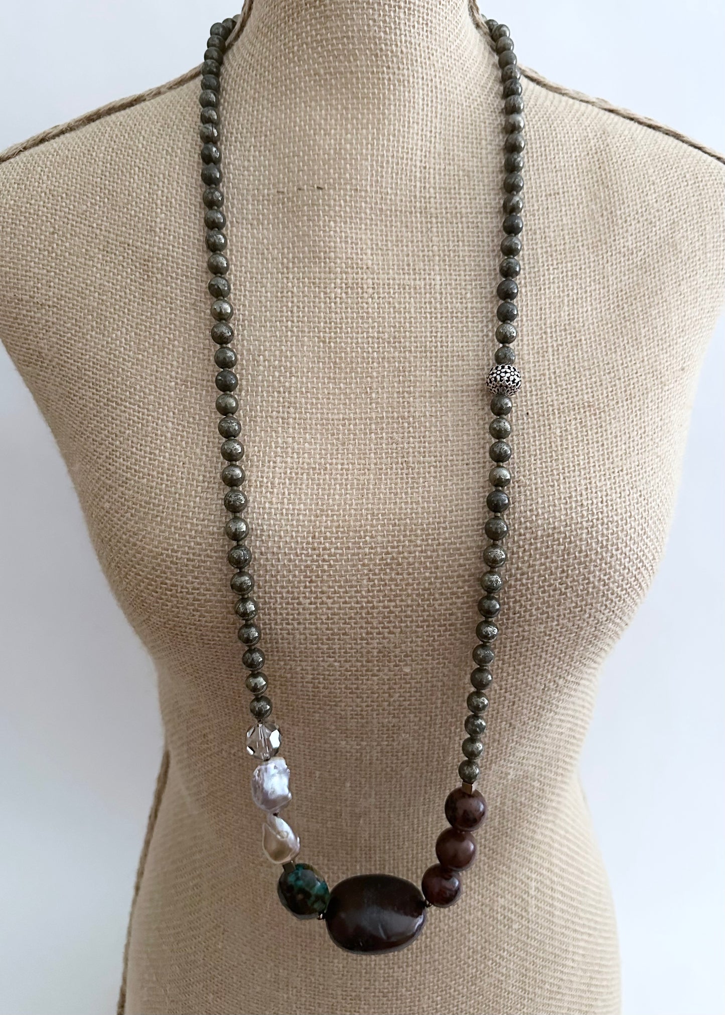 This Unique Long (40”) Necklace Features a combination of Brown Turquoise, Mahogany Obsidian, Pyrite, Crystal, Baroque Freshwater Pearls, finished with Silver and Gold Accents and a Charm Clasp. Wear it Long or Double it up!