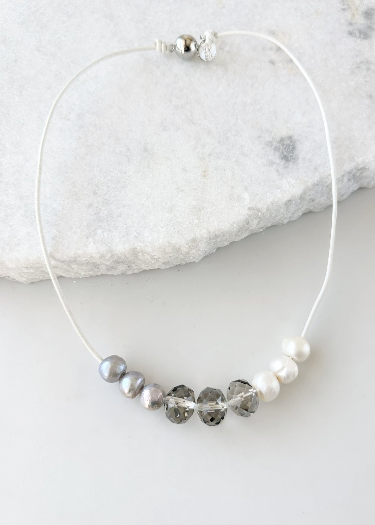 Designed in Canada, the 20” Carly Necklace gives a fun casual look with Three Large 16mm Crystals (Smoke or Champagne) surrounded by Pearls Floating on leather. It's Finished with a Magnetic Clasp for Easy Wear.