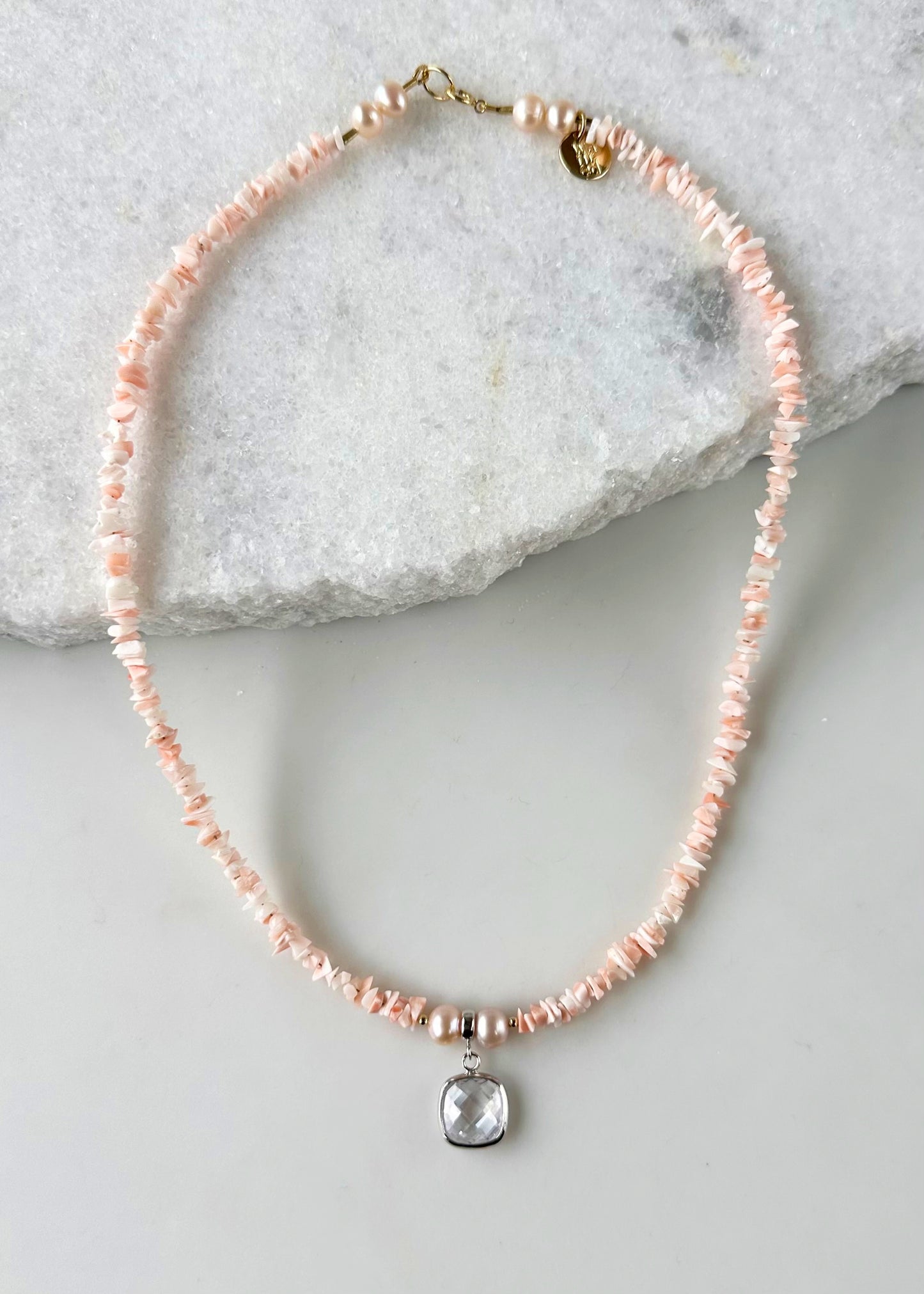 Designed and made in Canada, this Limited Edition 18.25” Necklace features coral with a clear Crystal Pendant framed in Silver and beautiful Peach Pearls.  It is accented with a touch of Gold (Gold filled spring ring clasp, Gold filled beads (2mm) ) for a two-tone look that's perfect for summer.  