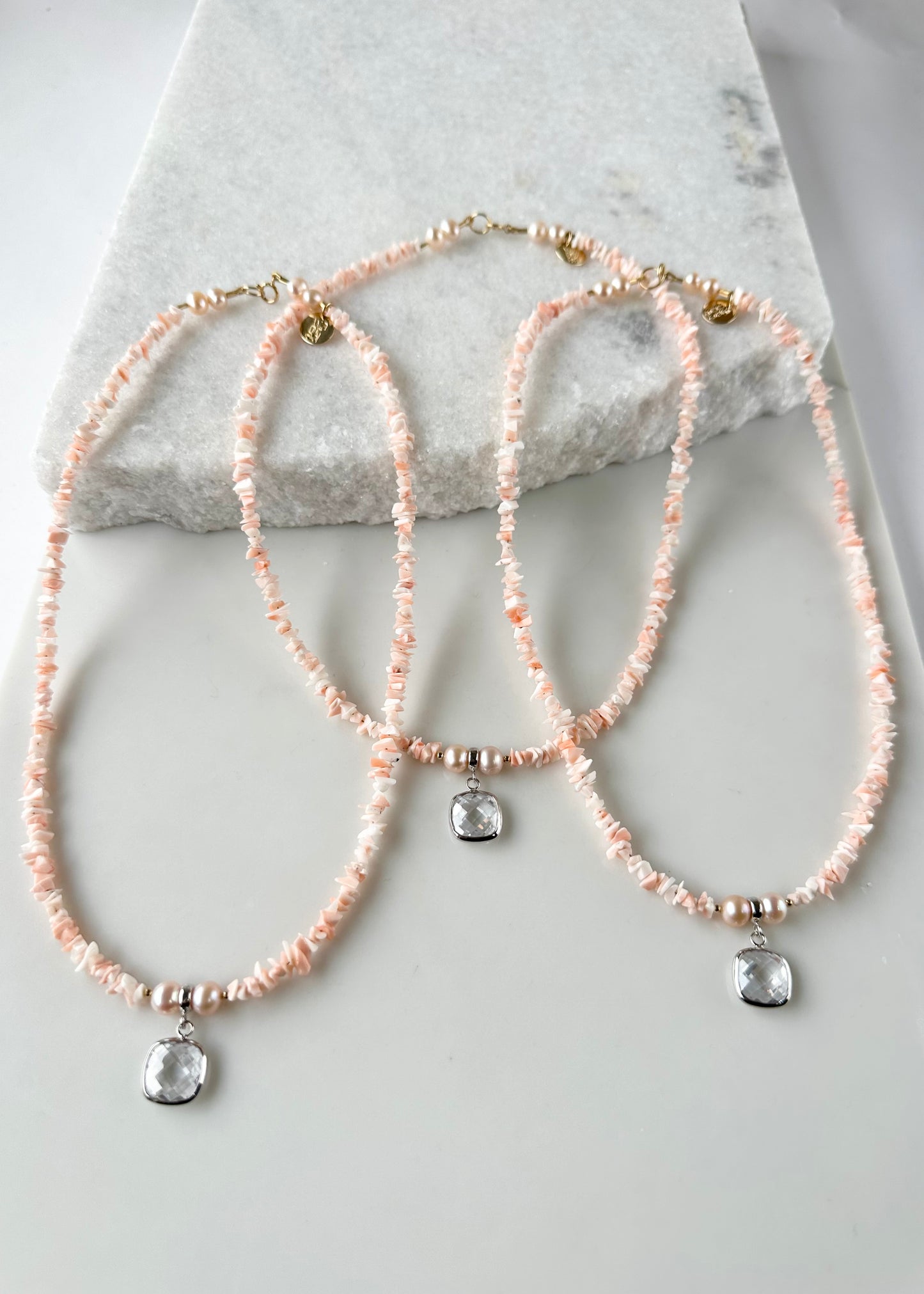 Designed and made in Canada, this Limited Edition 18.25” Necklace features coral with a clear Crystal Pendant framed in Silver and beautiful Peach Pearls.  It is accented with a touch of Gold (Gold filled spring ring clasp, Gold filled beads (2mm) ) for a two-tone look that's perfect for summer.  