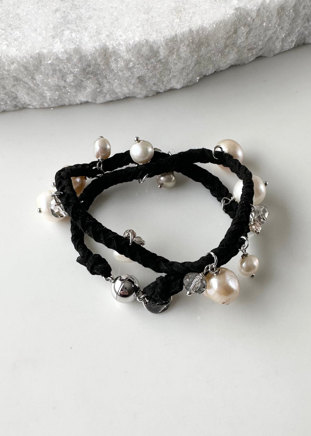 White and Champagne Baroque, Freshwater Pearls hang from this 14” Double Wrap Bracelet made of Vegan Suede in Black.  The piece is completed with crystal accents and a Strong Secure Magnetic Clasp for Easy Wear.