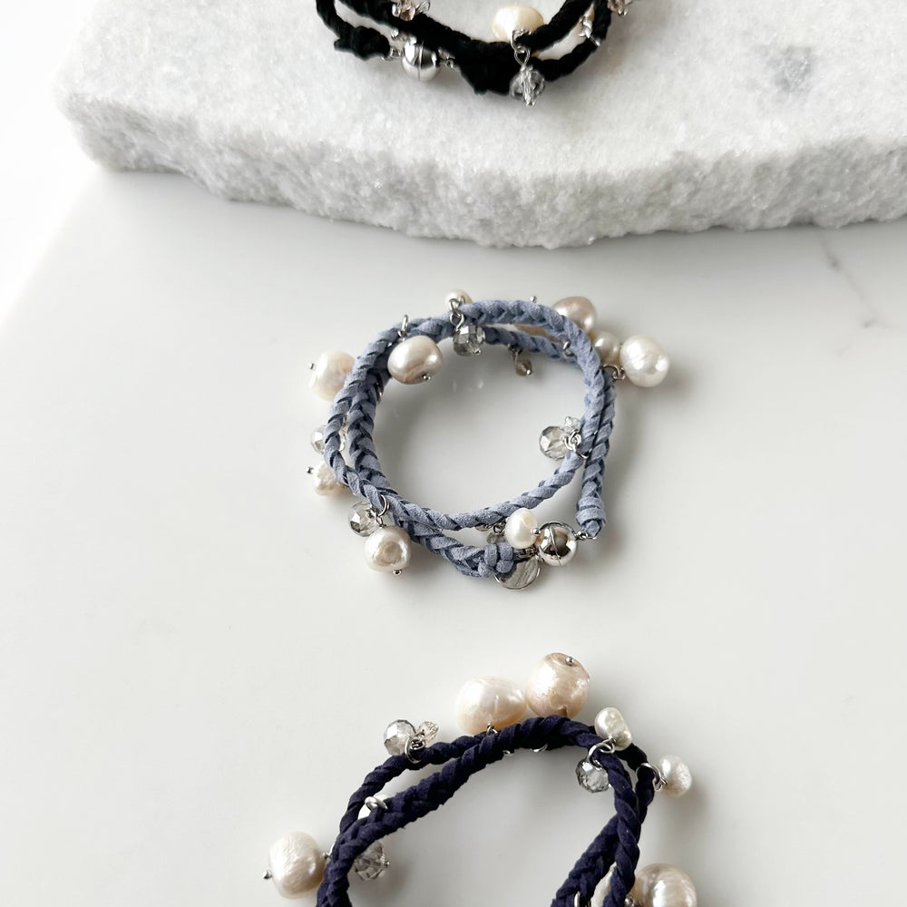 
                      
                        White and Champagne Baroque, Freshwater Pearls hang from this 14” Double Wrap Bracelet made of Vegan Suede in Blue, Black or Navy.  The piece is completed with crystal accents and a Strong Secure Magnetic Clasp for Easy Wear.
                      
                    