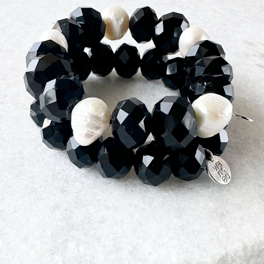
                      
                        White Freshwater Pearls are joined by Black Faceted Crystals in the Stretch Bracelet. Two shown
                      
                    