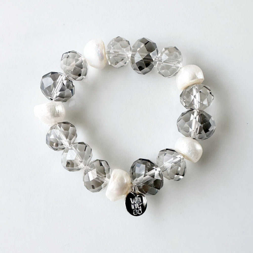 
                      
                        White Freshwater Pearls are joined by Smoke Faceted Crystals in the Stretch Bracelet.
                      
                    