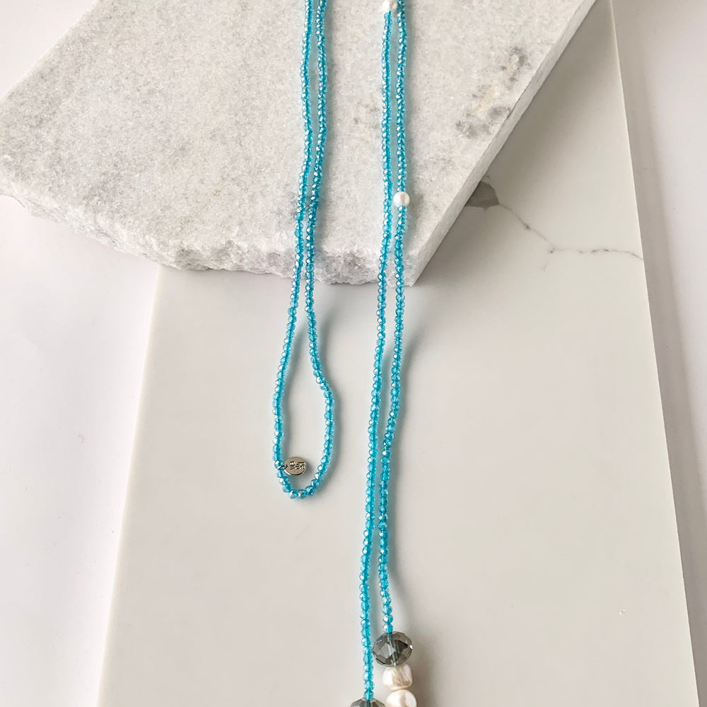 Long, 64-inch Lariat-Style Necklace with Blue Crystals and White Freshwater Pearls.  This Versatile piece allows it to be worn in many ways.