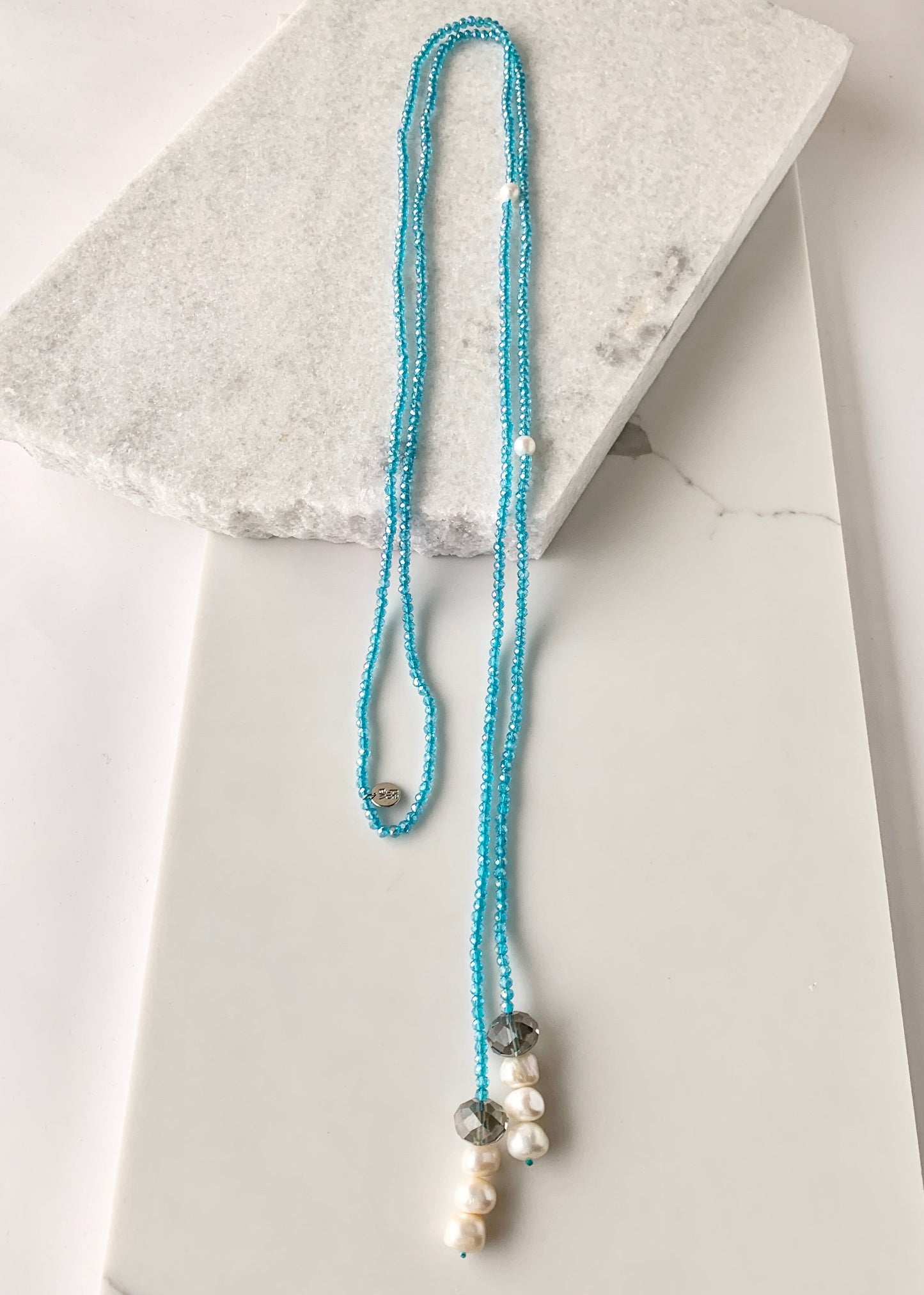 Long, 64-inch Lariat-Style Necklace with Blue Crystals and White Freshwater Pearls.  This Versatile piece allows it to be worn in many ways.