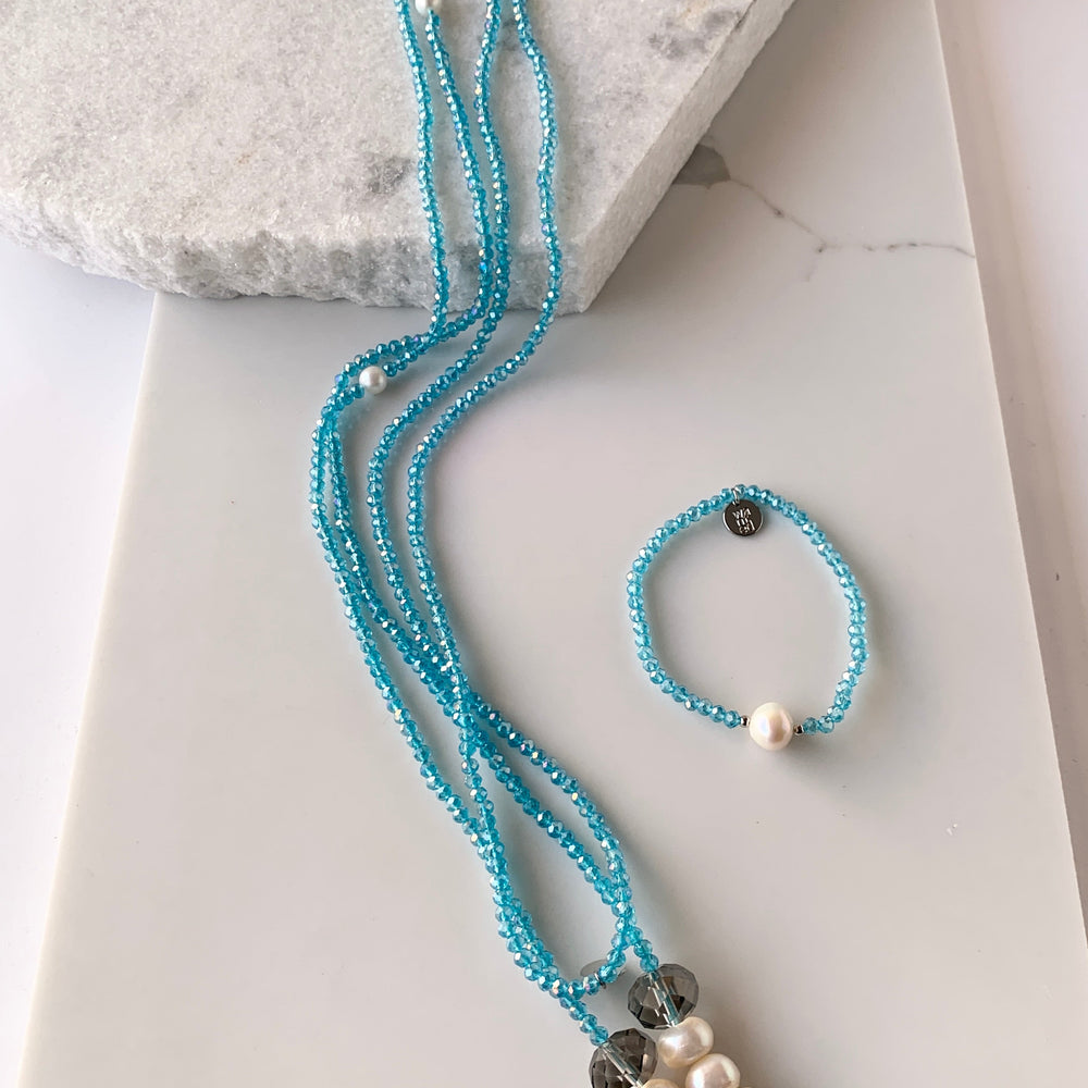 
                      
                        Long, 64-inch Lariat-Style Necklace with Blue Crystals and White Freshwater Pearls.  This Versatile piece allows it to be worn in many ways. Shown with matching Bracelet
                      
                    