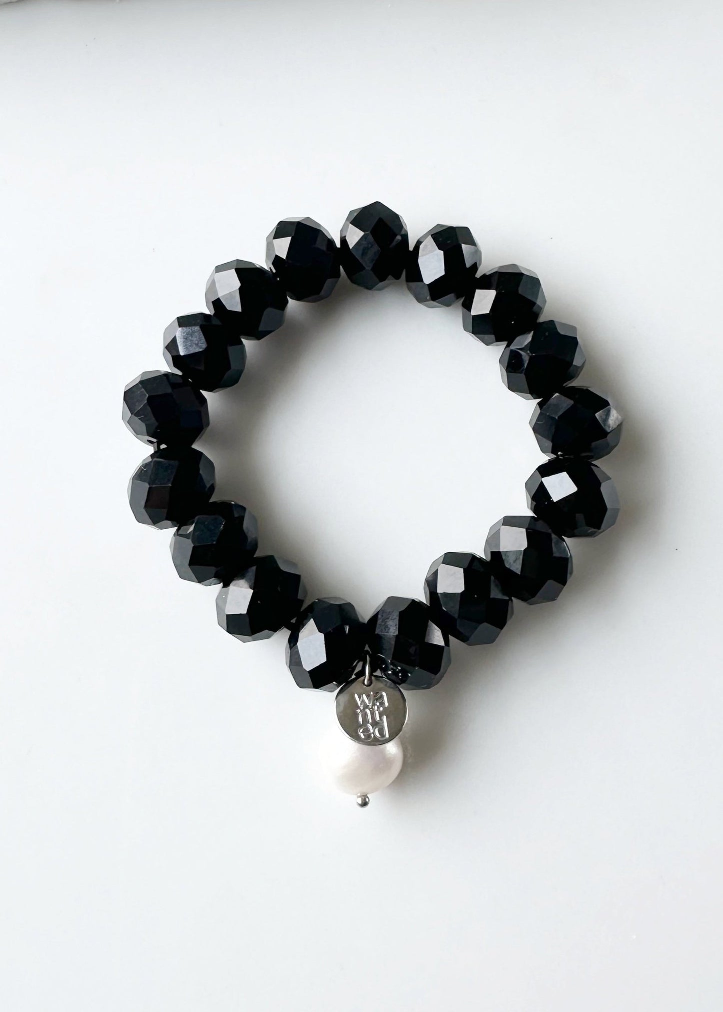 Stretch Bracelet of Large Faceted Black Crystals Accented with a White Freshwater Pearl Dangle.