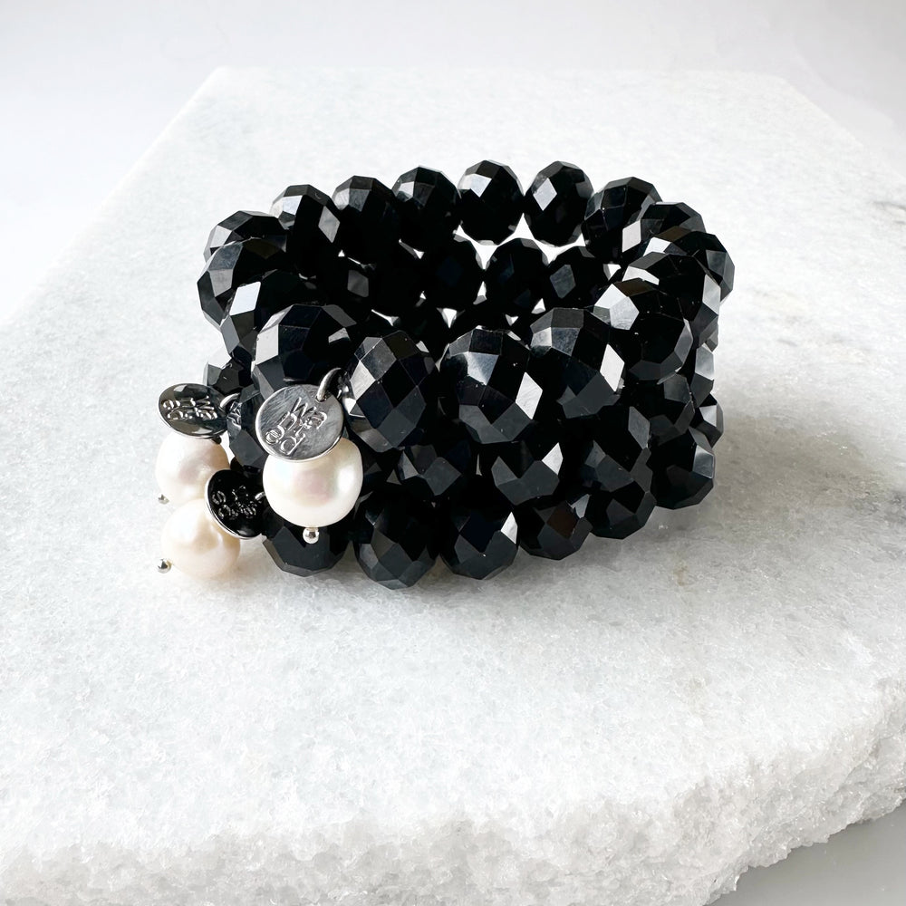 
                      
                        Stretch Bracelet of Large Faceted Black Crystals Accented with a White Freshwater Pearl Dangle. Stacked
                      
                    