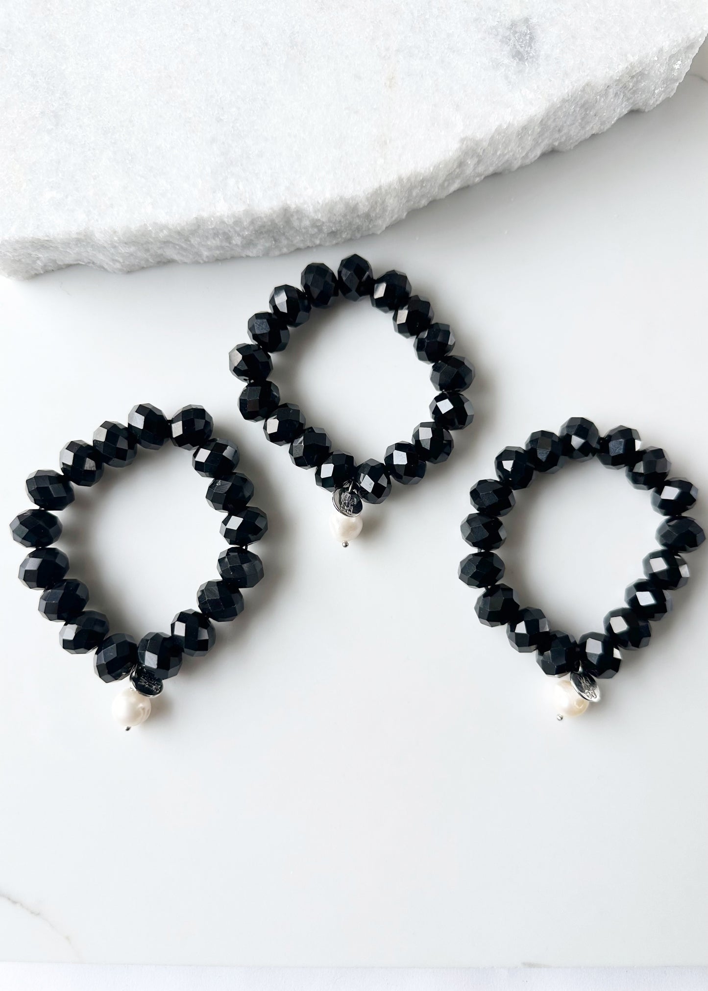 Stretch Bracelet of Large Faceted Black Crystals Accented with a White Freshwater Pearl Dangle. Three shown.