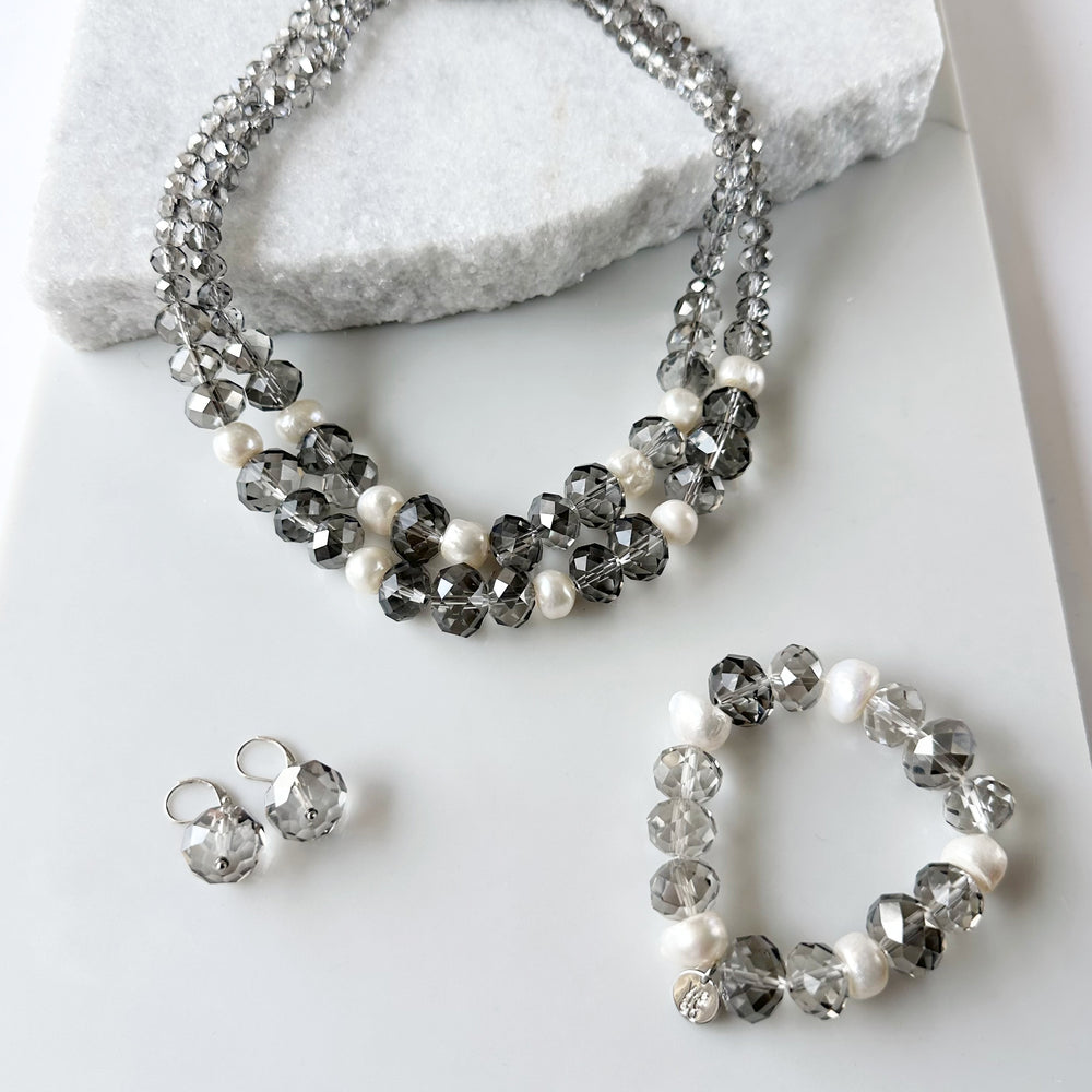 
                      
                        Two Strand White Freshwater Pearl Necklace with Large Faceted Smoke Crystals Joined by a Strong Secure Magnetic Clasp for Easy Wear.  Shown with Matching Bracelet and Earrings.
                      
                    