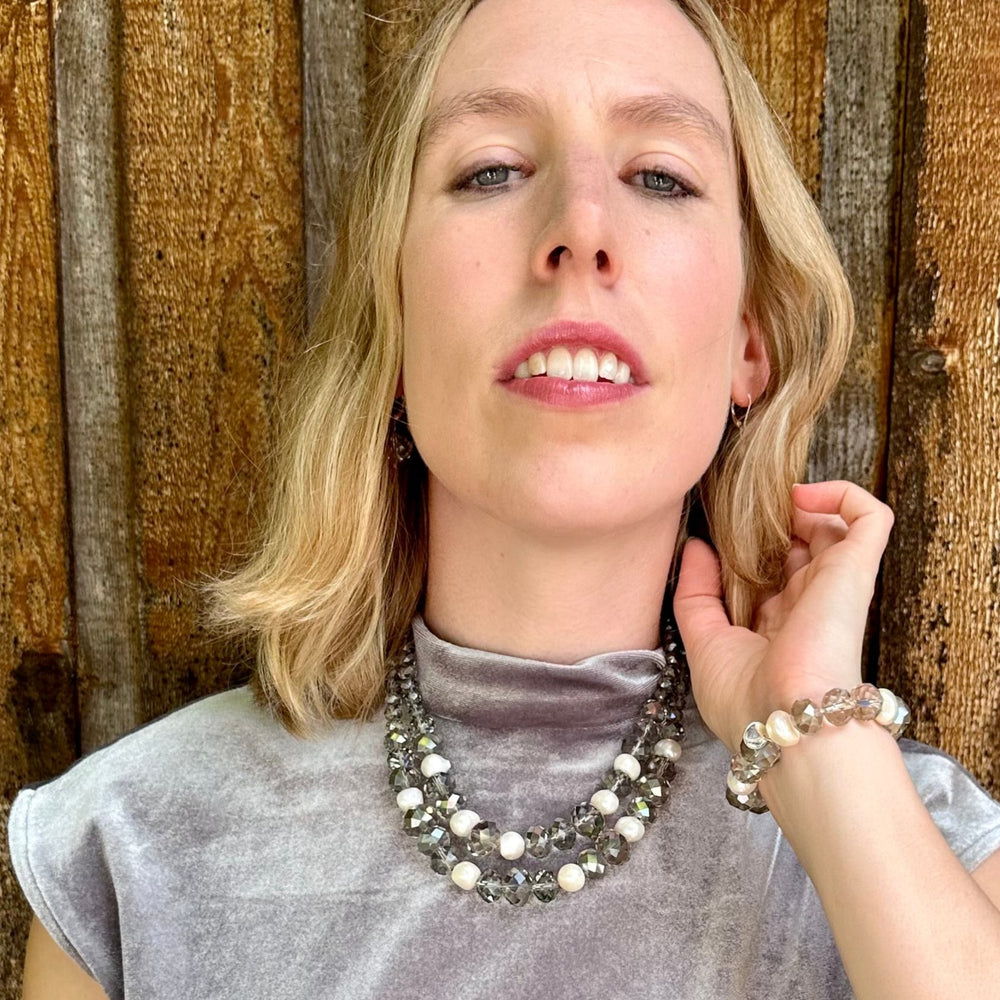 
                      
                        Two Strand White Freshwater Pearl Necklace with Large Faceted Smoke Crystals Joined by a Strong Secure Magnetic Clasp for Easy Wear.  Worn by Model with Matching Bracelet
                      
                    