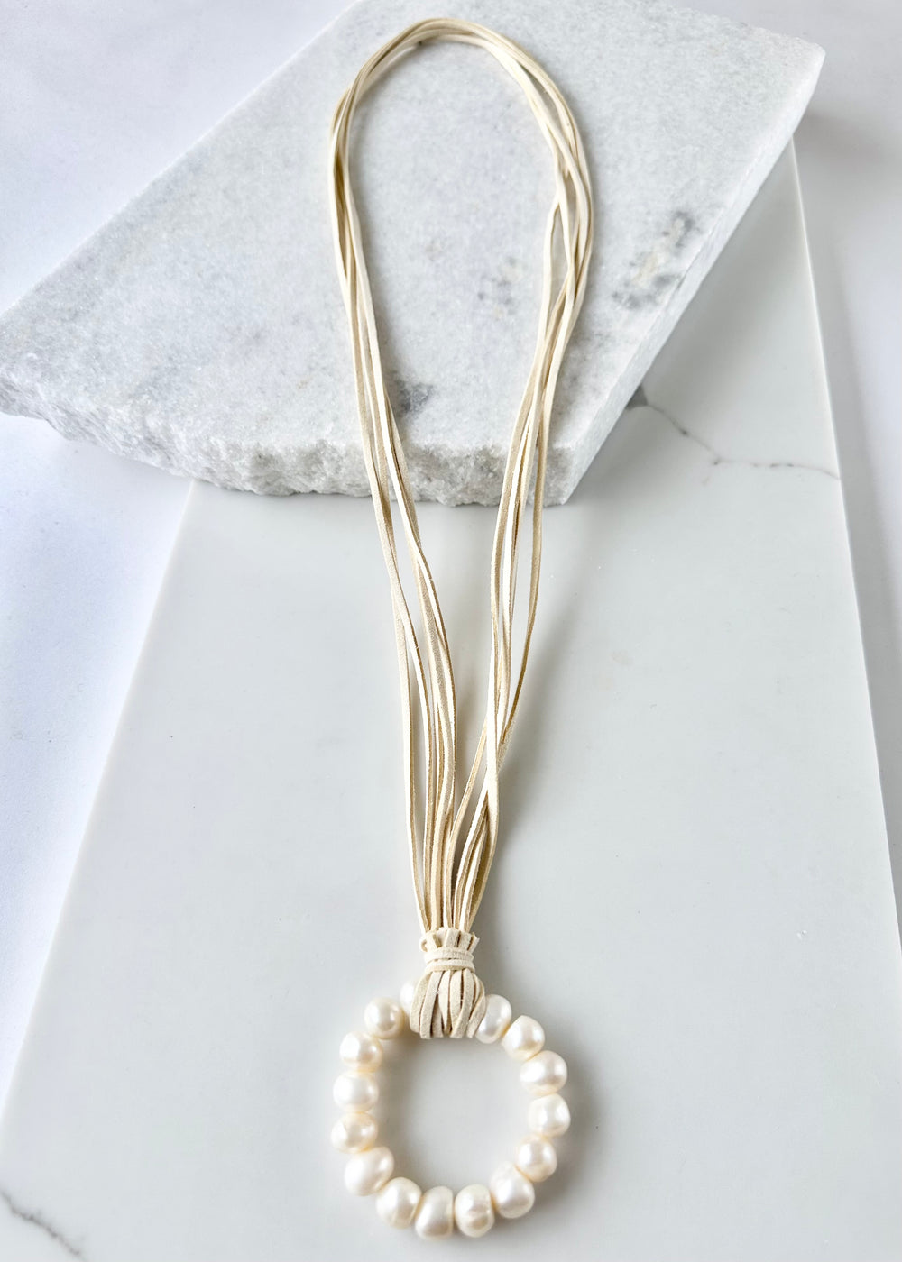 Necklace in Cream Vegan Suede Displaying a Large Ring Pendant of White Freshwater Pearls.