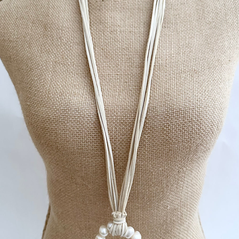 
                      
                        Necklace in Cream Vegan Suede Displaying a Large Ring Pendant of White Freshwater Pearls. On Bust
                      
                    