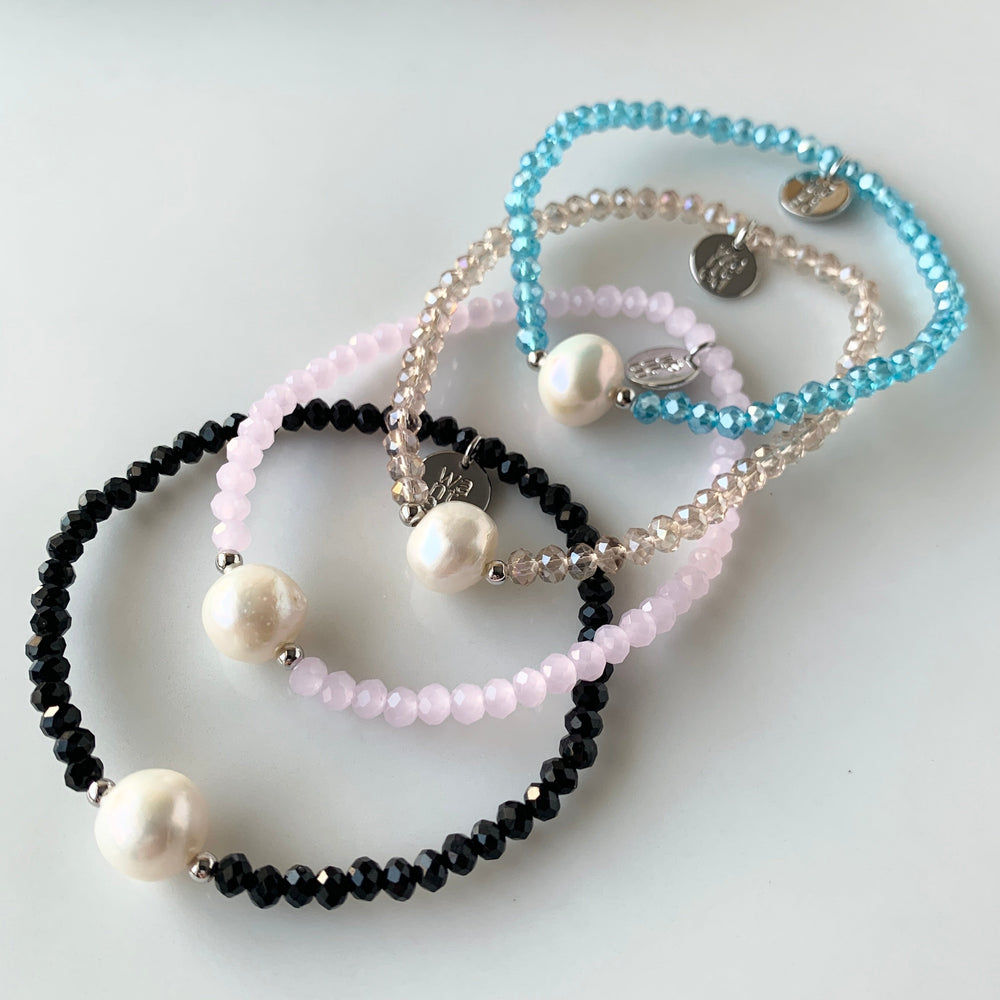 
                      
                        Shown Are All Four Colors of Faceted Crystal Bracelet with Large White Pearl Centered between two Silver Beads.
                      
                    