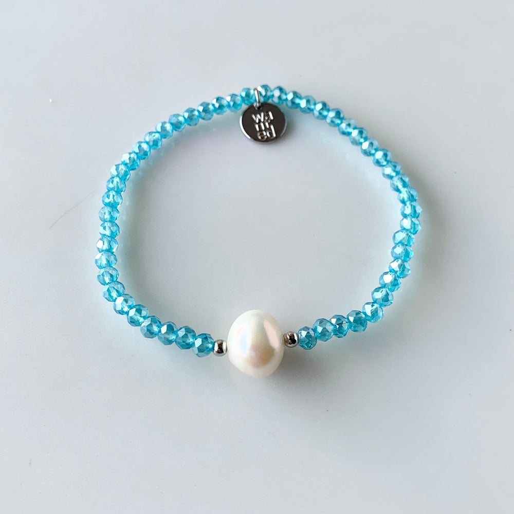 
                      
                        Blue Faceted Crystal Bracelet with Large White Pearl Centered between two Silver Beads.
                      
                    