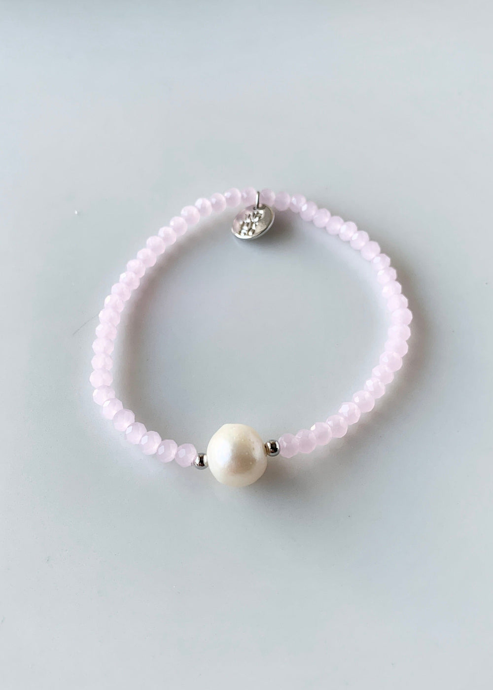 Pink Faceted Crystal Bracelet with Large White Pearl Centered between two Silver Beads.