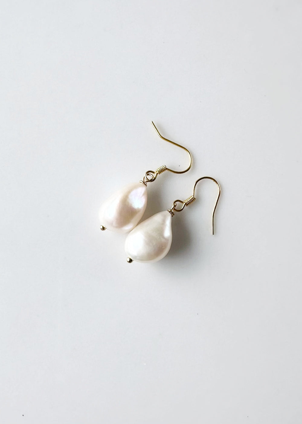 These White Baroque Freshwater Pearls drop from Gold-Plated Ear wires to complete a simple yet Elegant look.