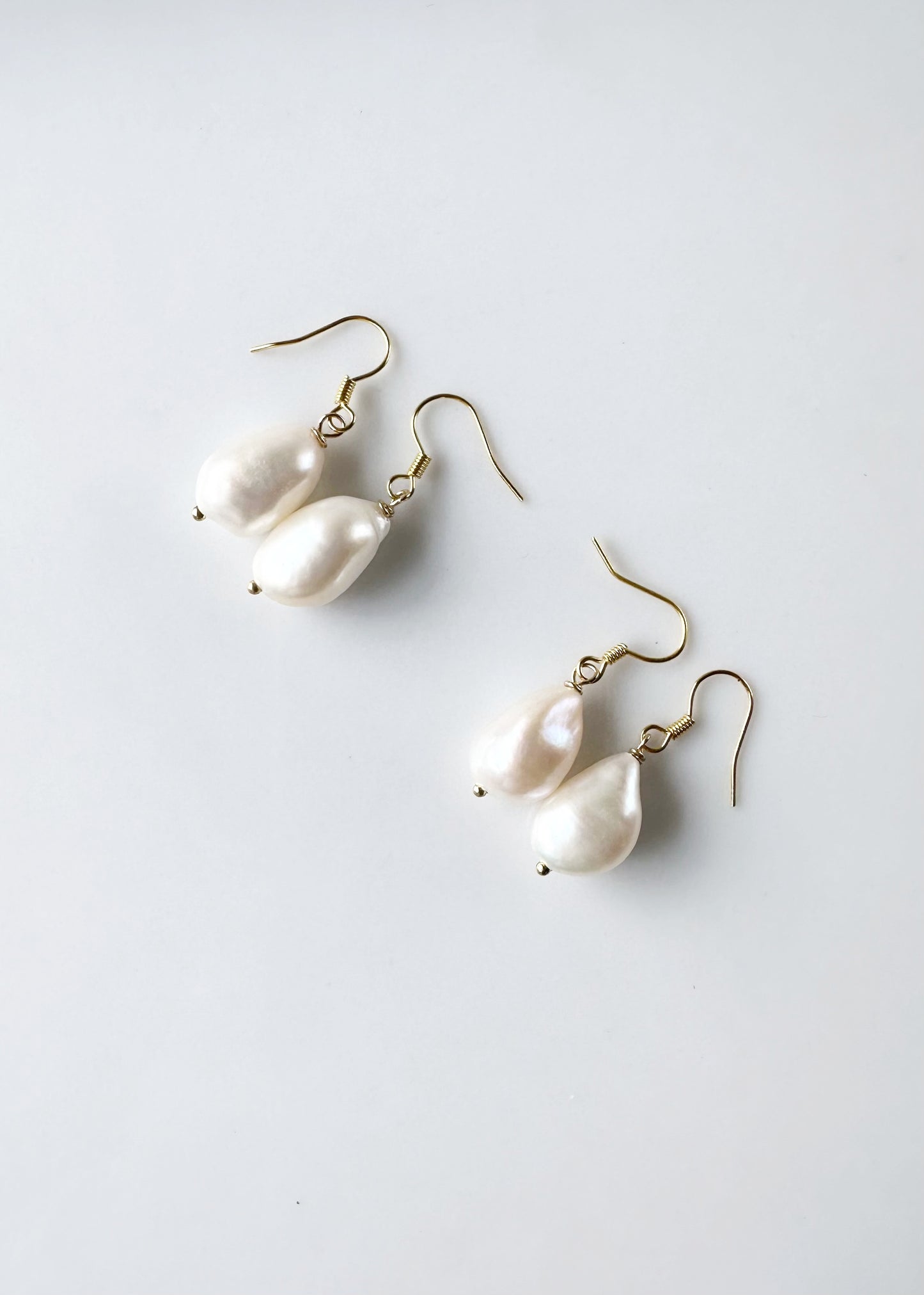 These White Baroque Freshwater Pearls drop from Gold-Plated Ear wires to complete a simple yet Elegant look. Two Pairs shown