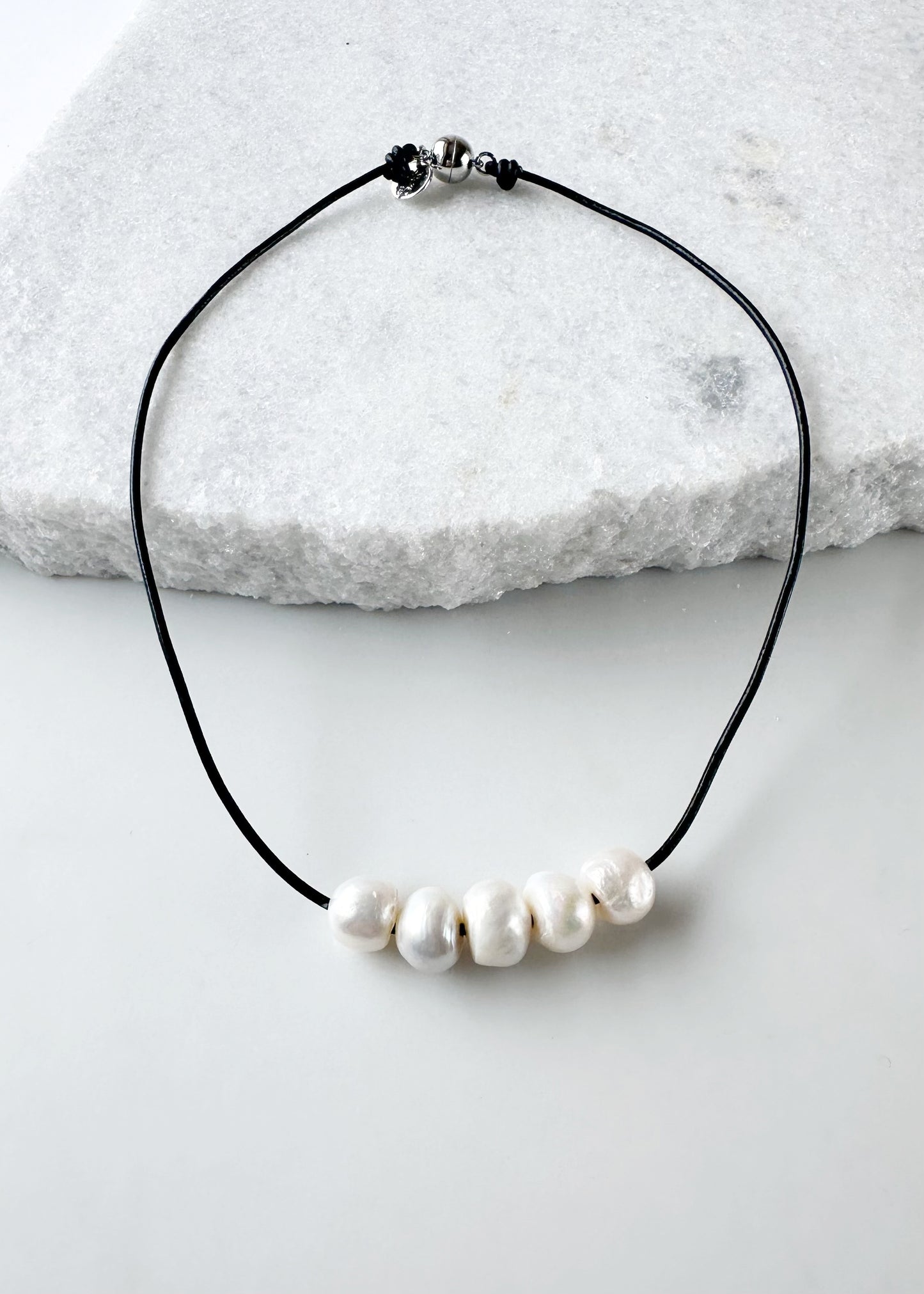 Five Large White Freshwater Pearls Floating on Black Leather secured by a Strong Magnetic Clasp for Easy wear.