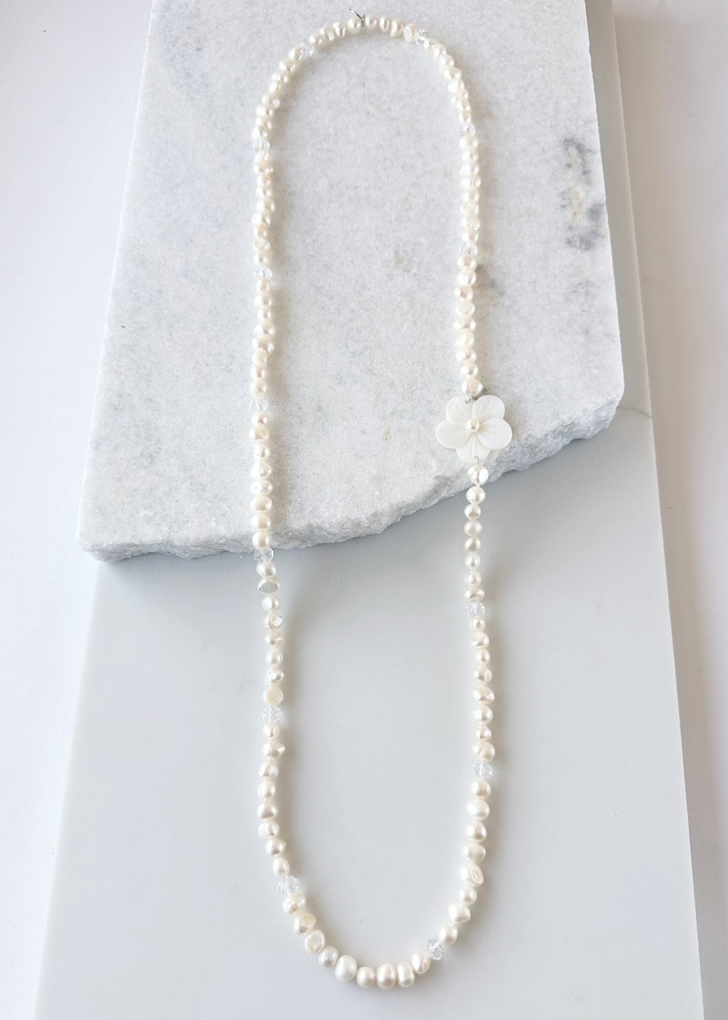 Designed in Canada, the Florence Necklace is so easy to wear with a Lustrous Strand of Baroque 8-9mm Pearls, a touch of Crystal and a Pretty, Carved Shell Flower that you can position where you like. The Drop is 18".  There is no clasp so just slip it on and enjoy.