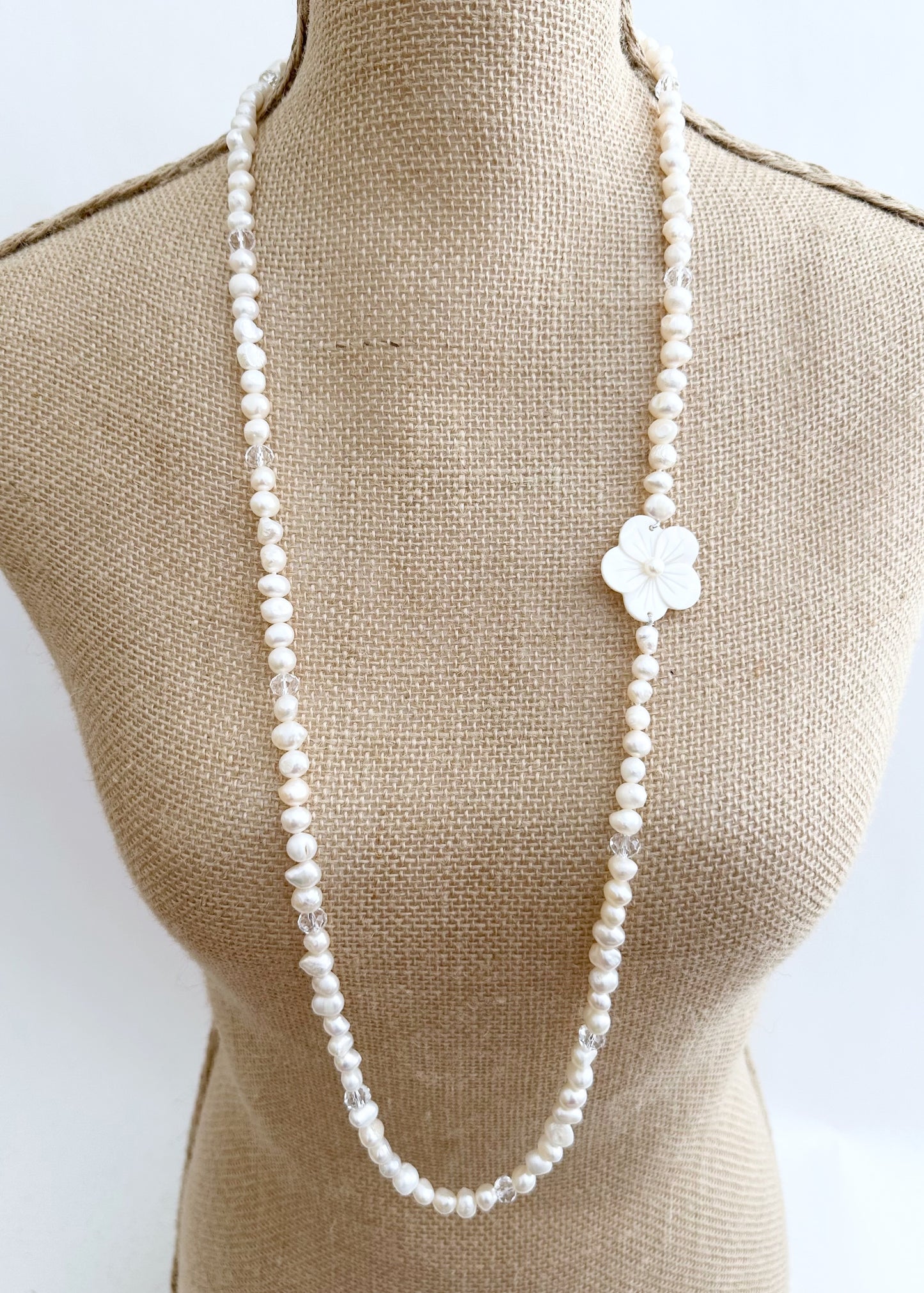 Designed in Canada, the Florence Necklace is so easy to wear with a Lustrous Strand of Baroque 8-9mm Pearls, a touch of Crystal and a Pretty, Carved Shell Flower that you can position where you like. The Drop is 18".  There is no clasp so just slip it on and enjoy.