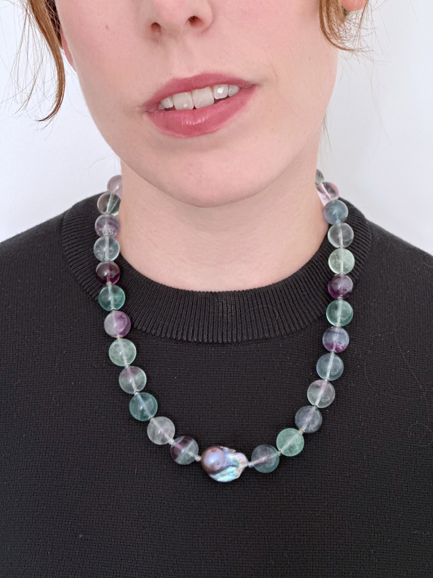 Designed and Made in Canada, this unique 20.5” Necklace features Striking Large Round Fluorite, Delicate Faceted Tourmaline, and a Stunning Peacock Baroque Pearl, creating an exquisite blend of vibrant colours. The piece is finished with a Sterling Silver Lobster Claw Clasp.