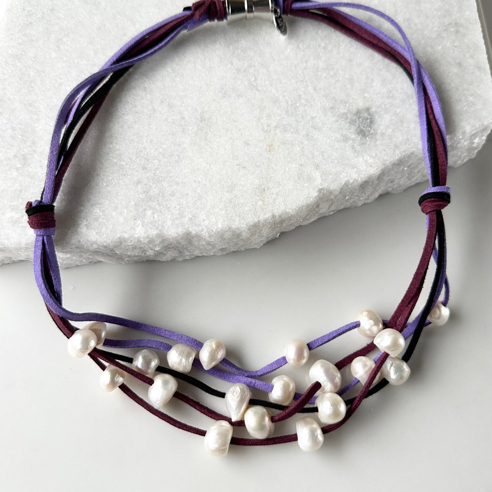 
                      
                        Five Strands of Purple Vegan Suede with Floating White Freshwater Pearls are Offered with a Strong Secure Magnetic Clasp for Easy Wear.
                      
                    