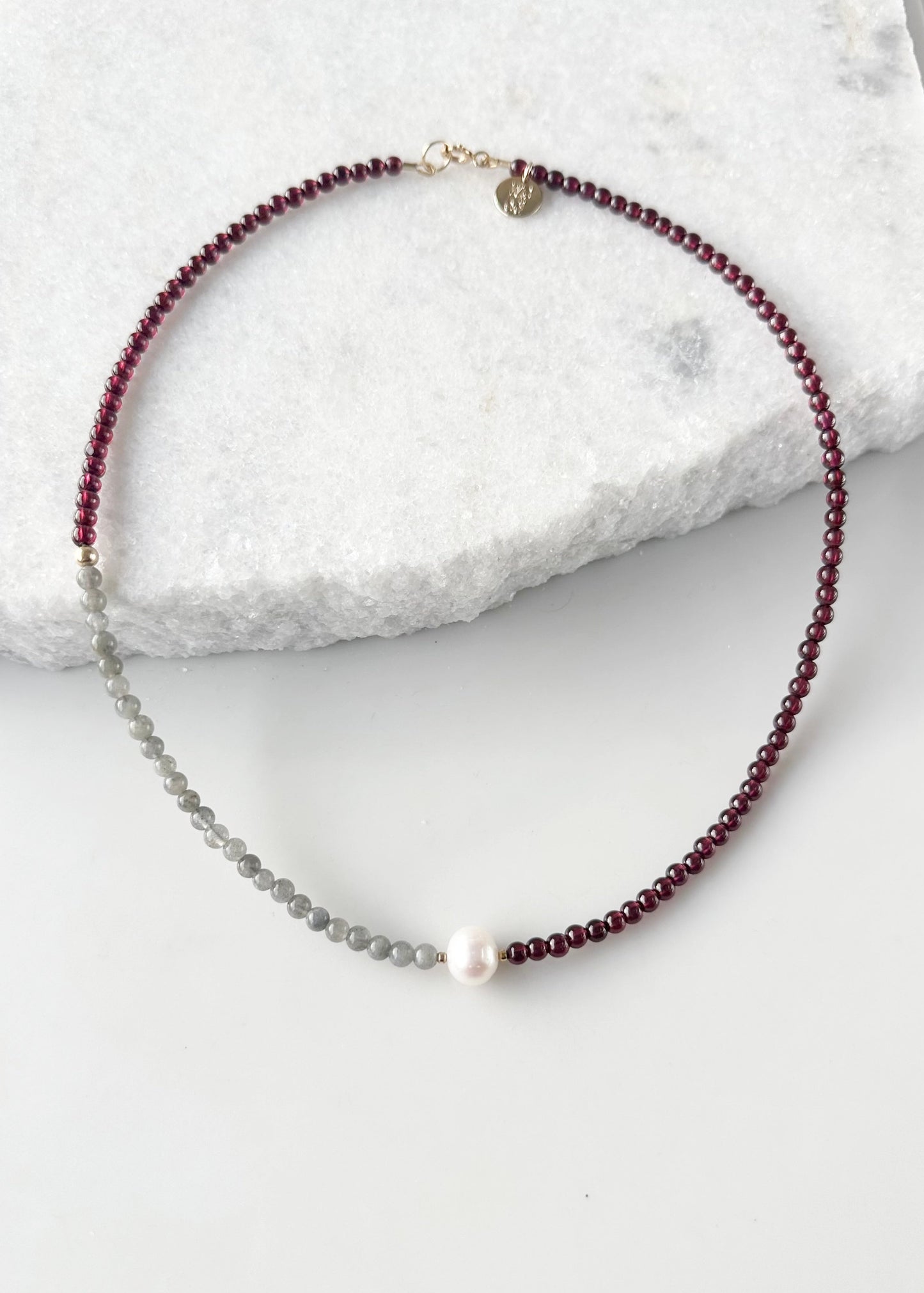 This 18.5" Limited-Edition Necklace, features Rich A+ Mozambique Garnet(4mm), Iridescent A+ Labradorite(4mm), and a Lustrous White A+ Pearl with Gold Accents. Designed and made in Canada, this piece is completed with a Gold-Filled Spring Ring Clasp.