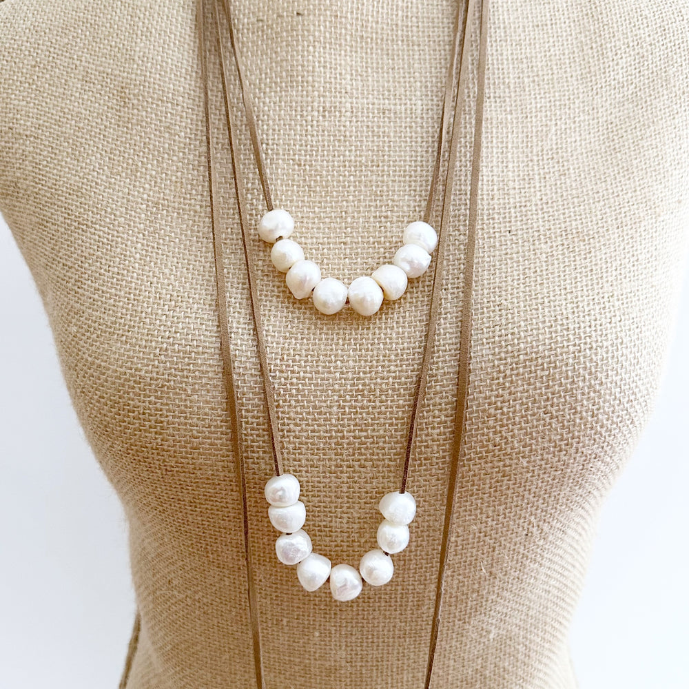 
                      
                        Three Strands of Beige Vegan Suede with Floating White Freshwater Pearls Completed with a Strong Secure Magnetic Clasp for Easy Wear. On Bust
                      
                    