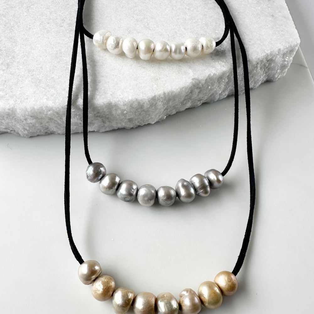 
                      
                        Three Strands of Black Vegan Suede with Floating White Silver and Gold Freshwater Pearls Completed with a Strong Secure Magnetic Clasp for Easy Wear. Magnified
                      
                    