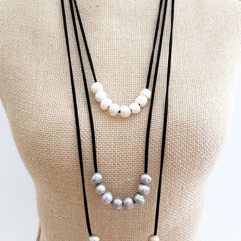 
                      
                        Three Strands of Black Vegan Suede with Floating White Silver and Gold Freshwater Pearls Completed with a Strong Secure Magnetic Clasp for Easy Wear. On Bust
                      
                    
