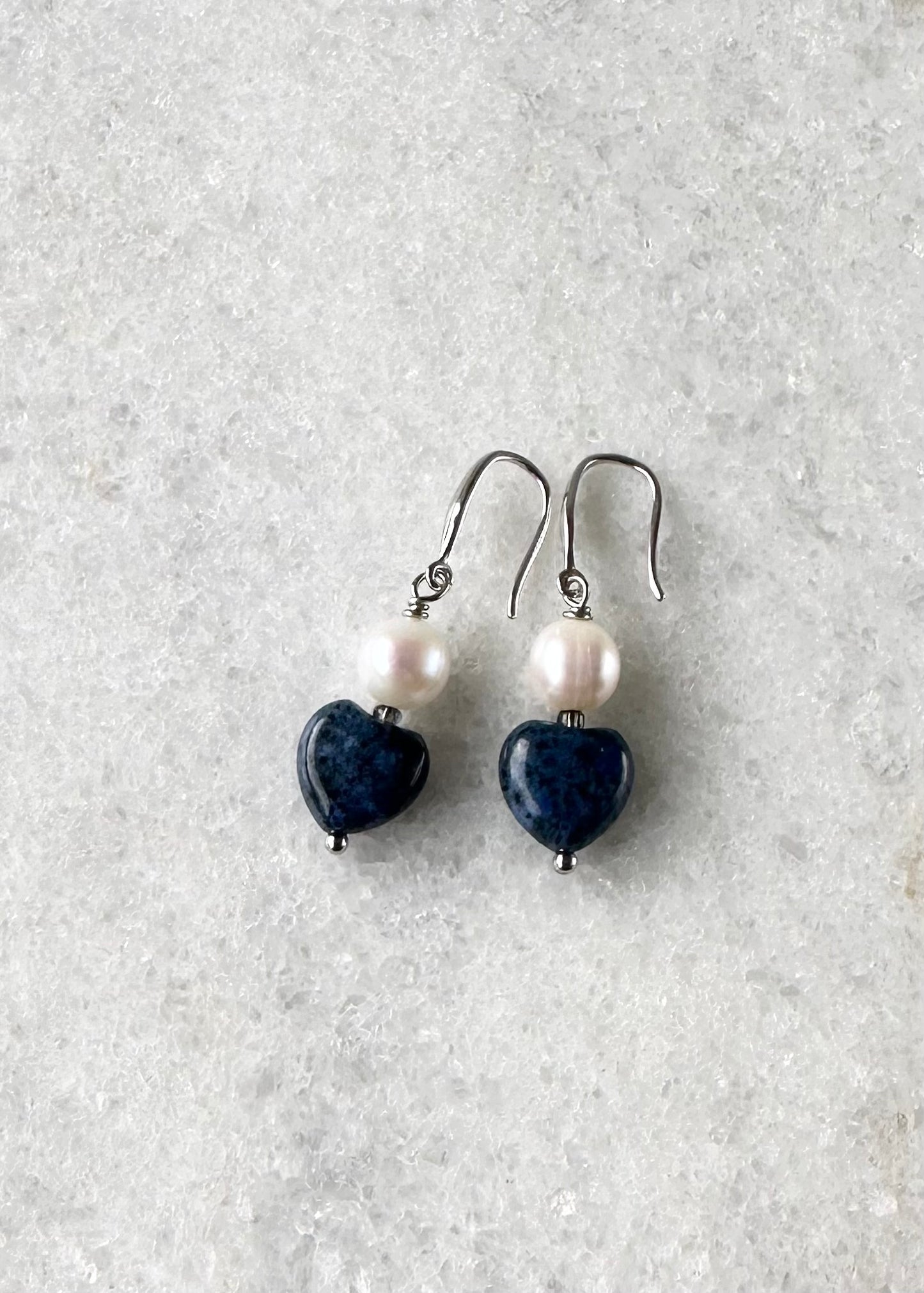 Designed and made in Canada, the Hope Earrings Feature Sweet Semi-Precious Stone Hearts with Lustrous Freshwater Pearls. The Length is 1 3/8" and they are Gold-Plated over Silver Fishhook.