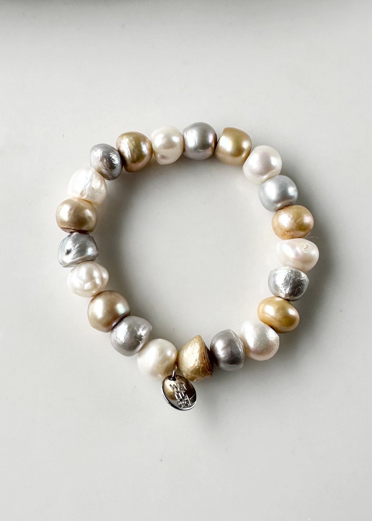 Mix of Large Baroque White, Gold and Silver Freshwater Pearls are designed in this Stretch Bracelet. This can be worn by itself or Stacked with others.