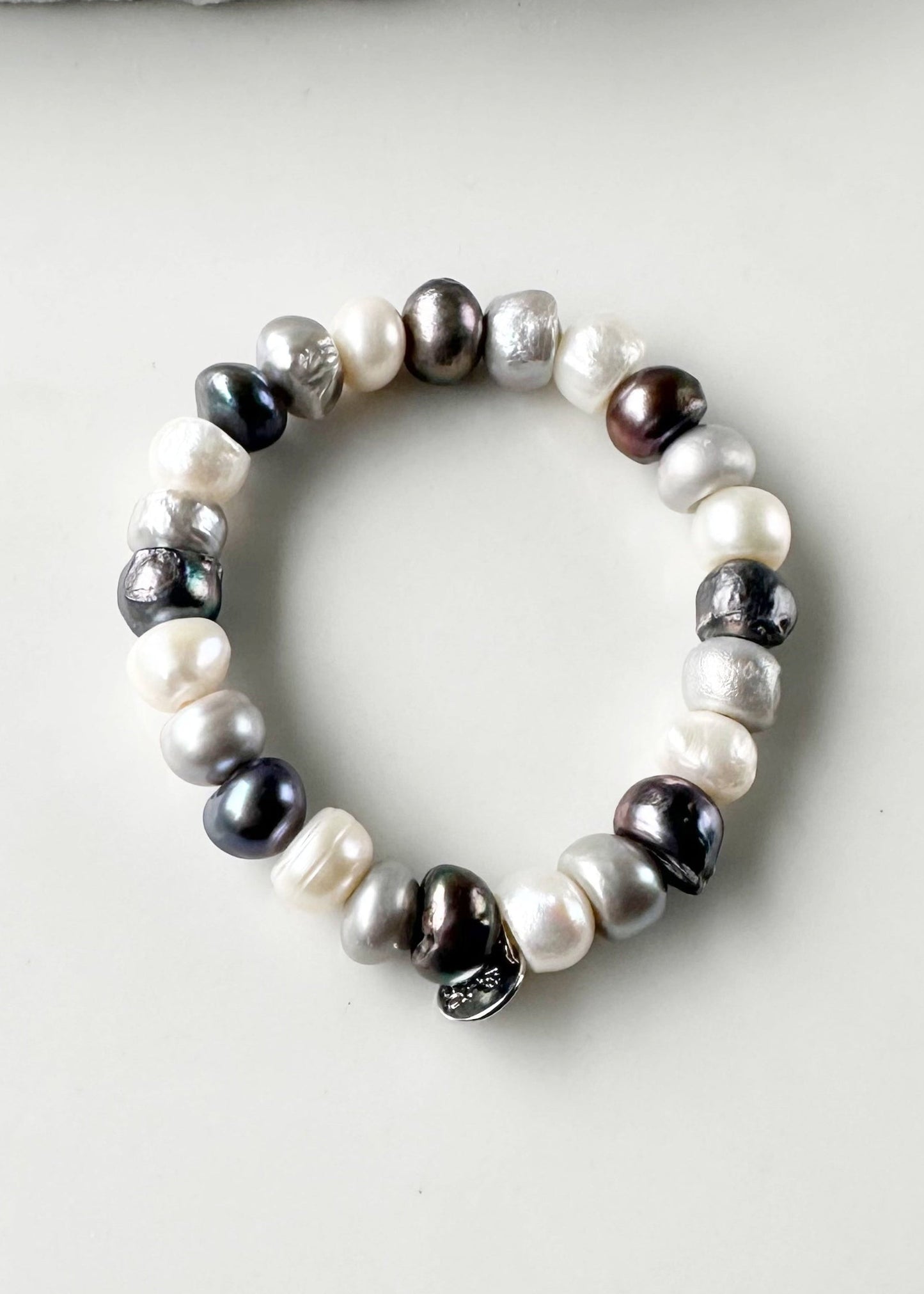 Mix of Large Baroque White, Silver and Black Freshwater Pearls are designed in this Stretch Bracelet. This can be worn by itself or Stacked with others.