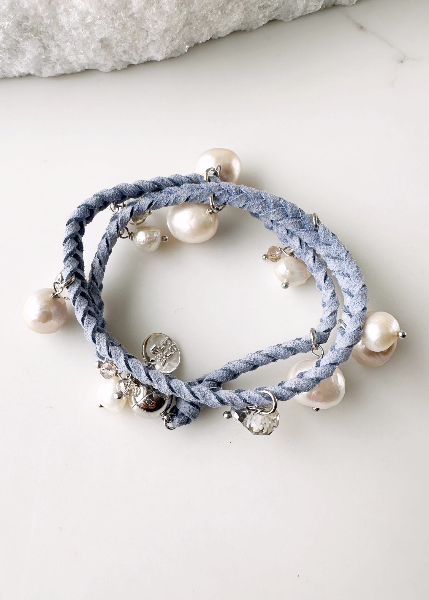 White and Champagne Baroque, Freshwater Pearls hang from this 14” Double Wrap Bracelet made of Vegan Suede in Blue.  The piece is completed with crystal accents and a Strong Secure Magnetic Clasp for Easy Wear.