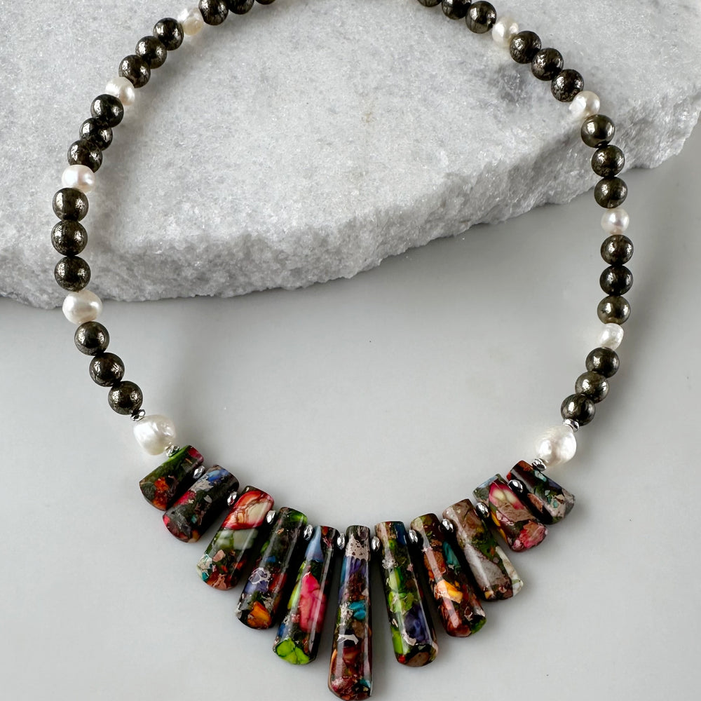 
                      
                        This Limited Edition Necklace is a Colorful Display of Impression Jasper, White Freshwater Pearls, Pyrite and Silver-Plated Hematite.  Designed and made in Canada, this Piece is fit with a Strong Magnetic Clasp for Easy Wear.  This is a Fun Piece that will go with Almost Anything.
                      
                    