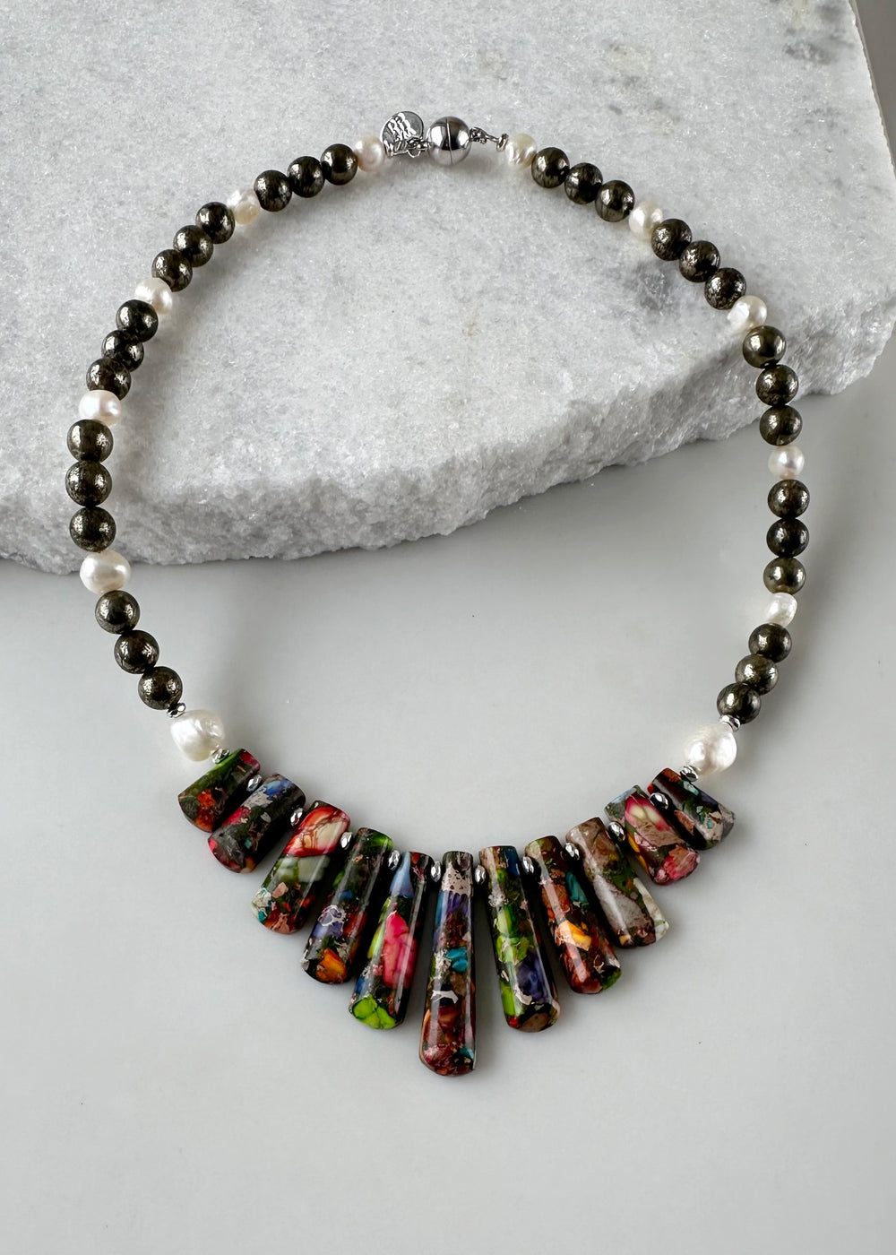 This Limited Edition Necklace is a Colorful Display of Impression Jasper, White Freshwater Pearls, Pyrite and Silver-Plated Hematite.  Designed and made in Canada, this Piece is fit with a Strong Magnetic Clasp for Easy Wear.  This is a Fun Piece that will go with Almost Anything.