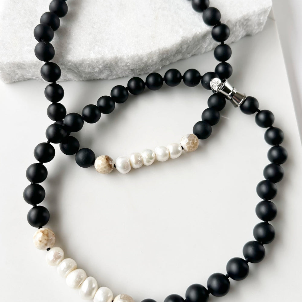 
                      
                        This 21” Necklace Showcases Five Radiant Pearls Accented by Faceted 14mm Beige Agate and Matte Black Agate Stones. It Fastens Effortlessly with a Convenient Magnetic Clasp, Combining Style and Ease. Designed in Canada
                      
                    