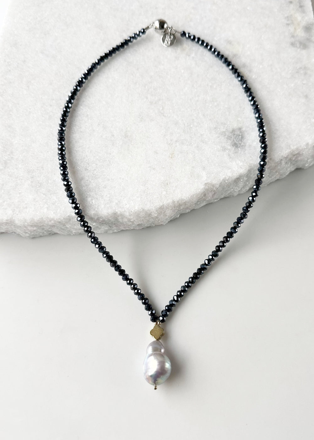 Faceted Navy Crystals form this Necklace with a Large White Baroque Freshwater Pearl Pendant Completed with Gold accents and a Strong Secure Magnetic Clasp for East Wear.