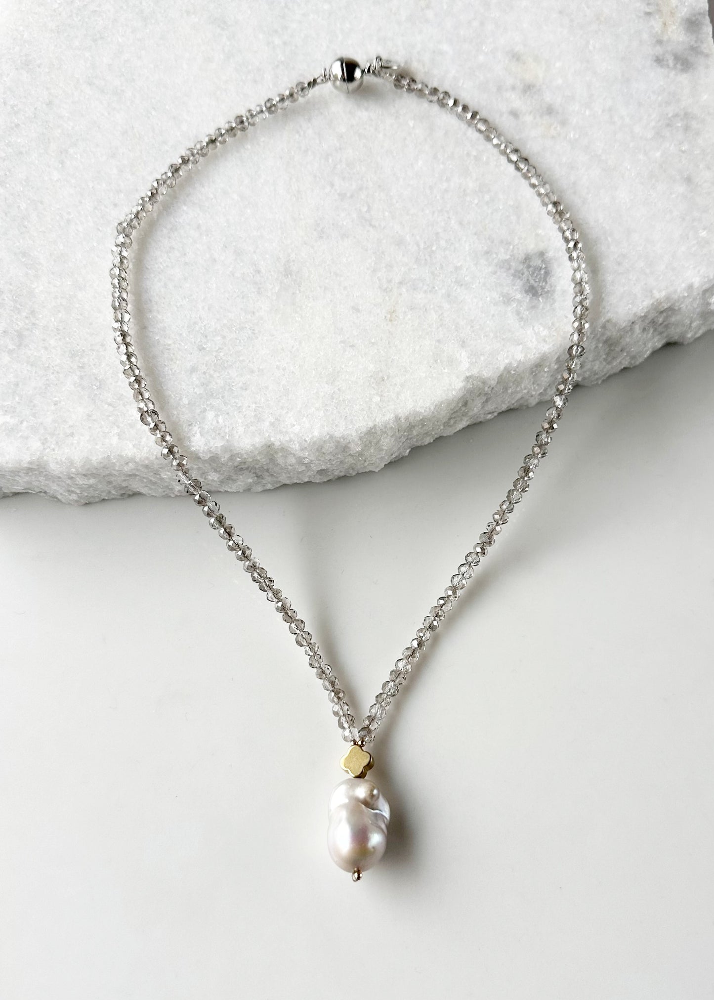 Faceted Smoke Crystals form this Necklace with a Large White Baroque Freshwater Pearl Pendant Completed with Gold accents and a Strong Secure Magnetic Clasp for East Wear.