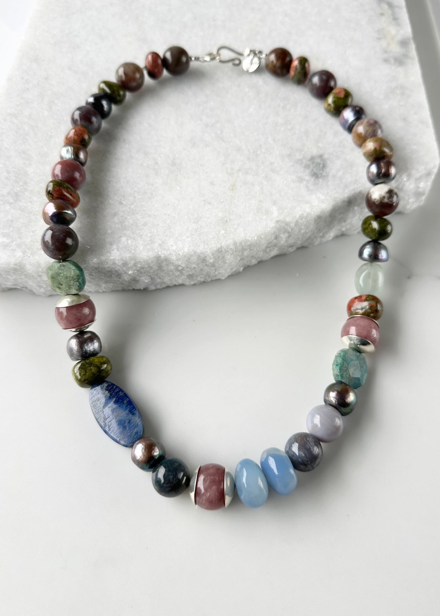 This Exceptional 22.5" Necklace Features a Blend of Jasper, Morango Quartz, Unakite, Fluorite, Dumortierite, Chrysocolla, Pearls, and Silver, with a Sterling silver hook clasp creating a truly one-of-a-kind statement piece. Designed and made in Canada