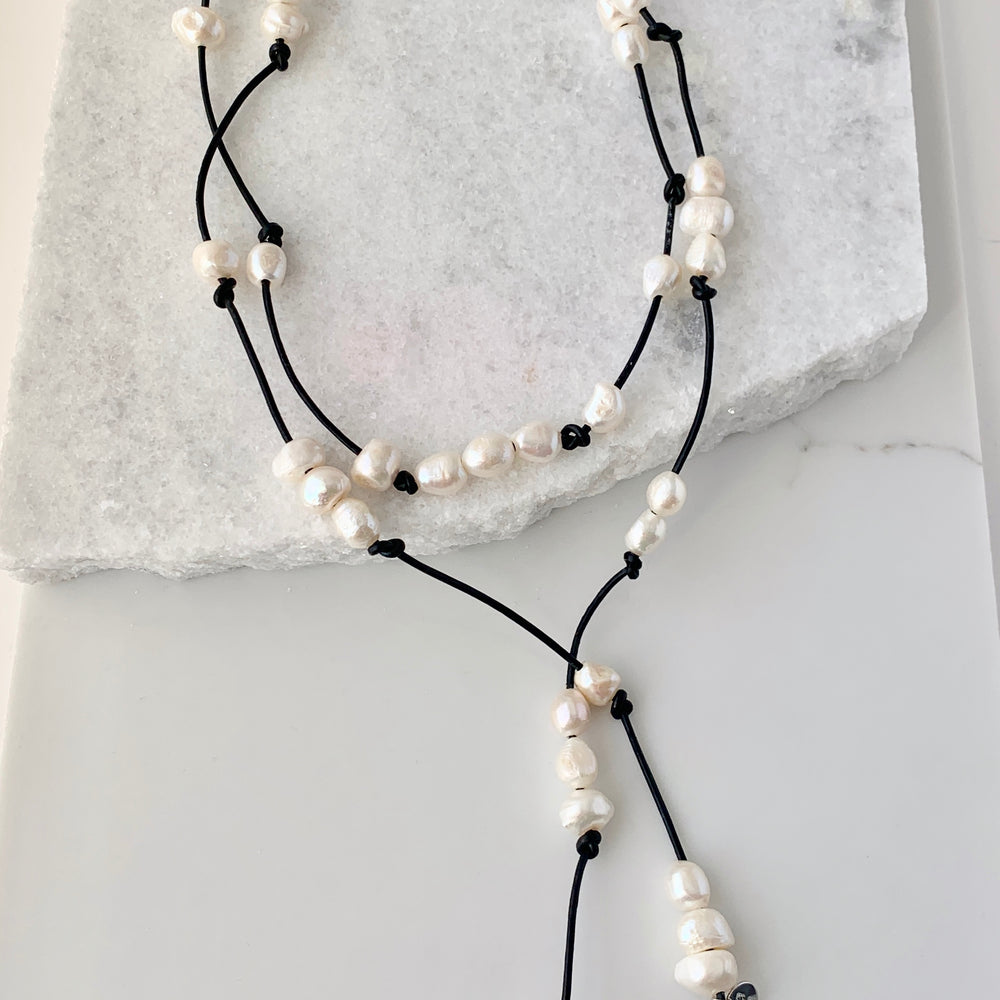 
                      
                        Long 46” Black Leather Lariat Adorned with Lustrous White Freshwater Pearls.  Can be worn Long, Doubled and in a Variety of Ways to Suit your Personal Taste and Mood.
                      
                    