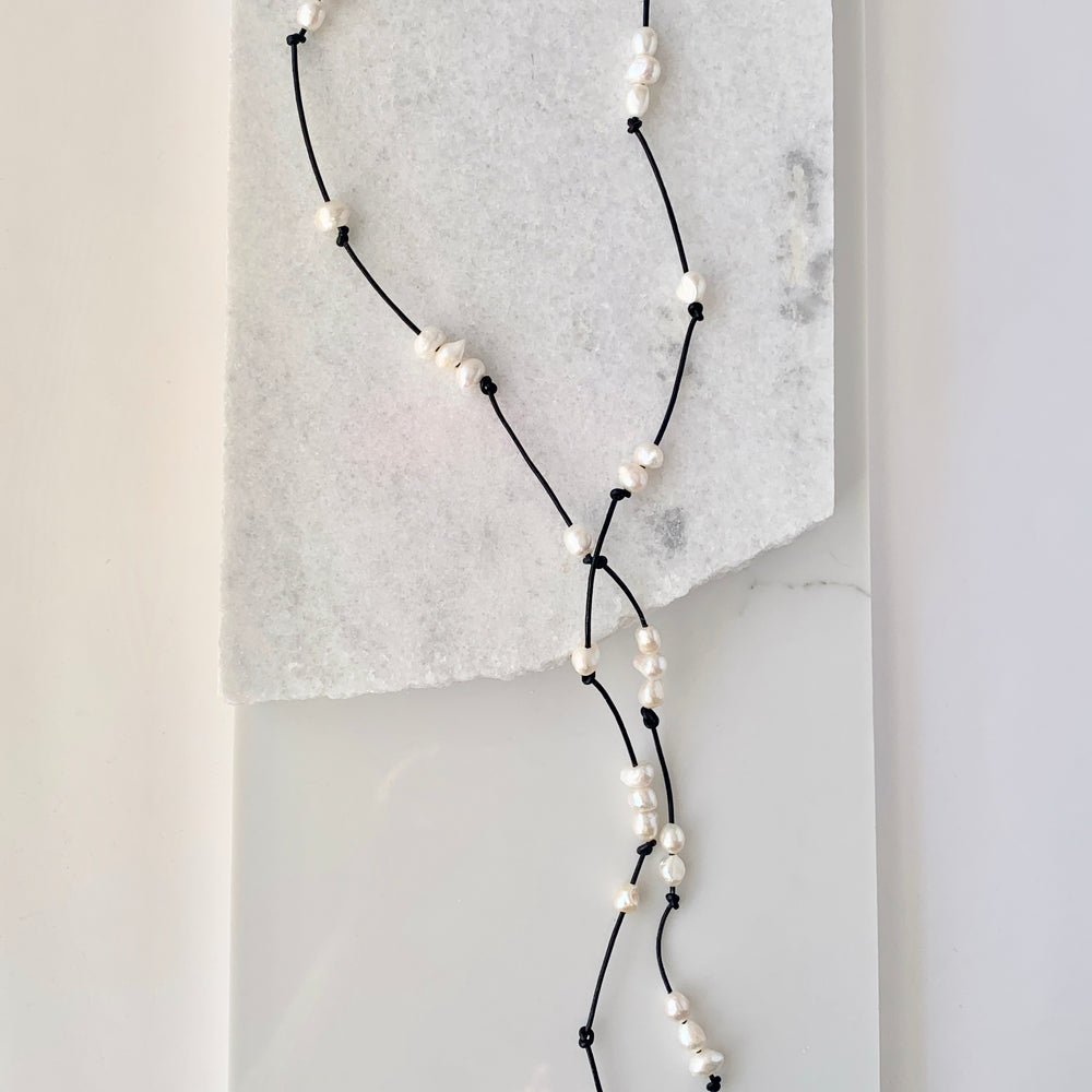 
                      
                        Long 46” Black Leather Lariat Adorned with Lustrous White Freshwater Pearls.  Can be worn Long, Doubled and in a Variety of Ways to Suit your Personal Taste and Mood. Focus on 46" Length.
                      
                    