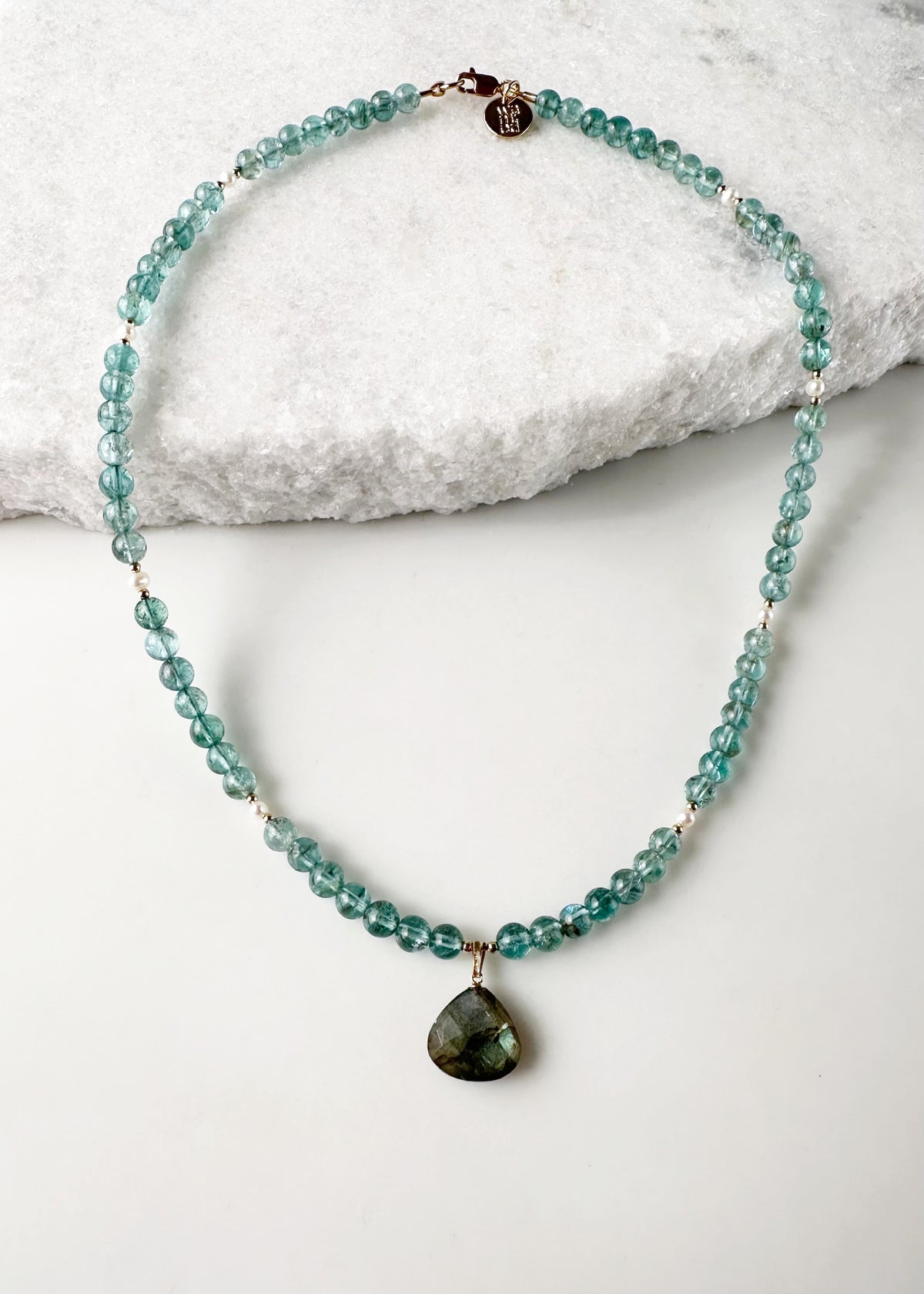 Designed and made in Canada, this one-of-a-kind 18.5” Necklace features beautiful Gemmy Apatite (AA grade) in a blue/green shade, with a Labradorite Pendant and tiny Pearls accented with Gold beads and finished with a Gold-filled lobster claw clasp