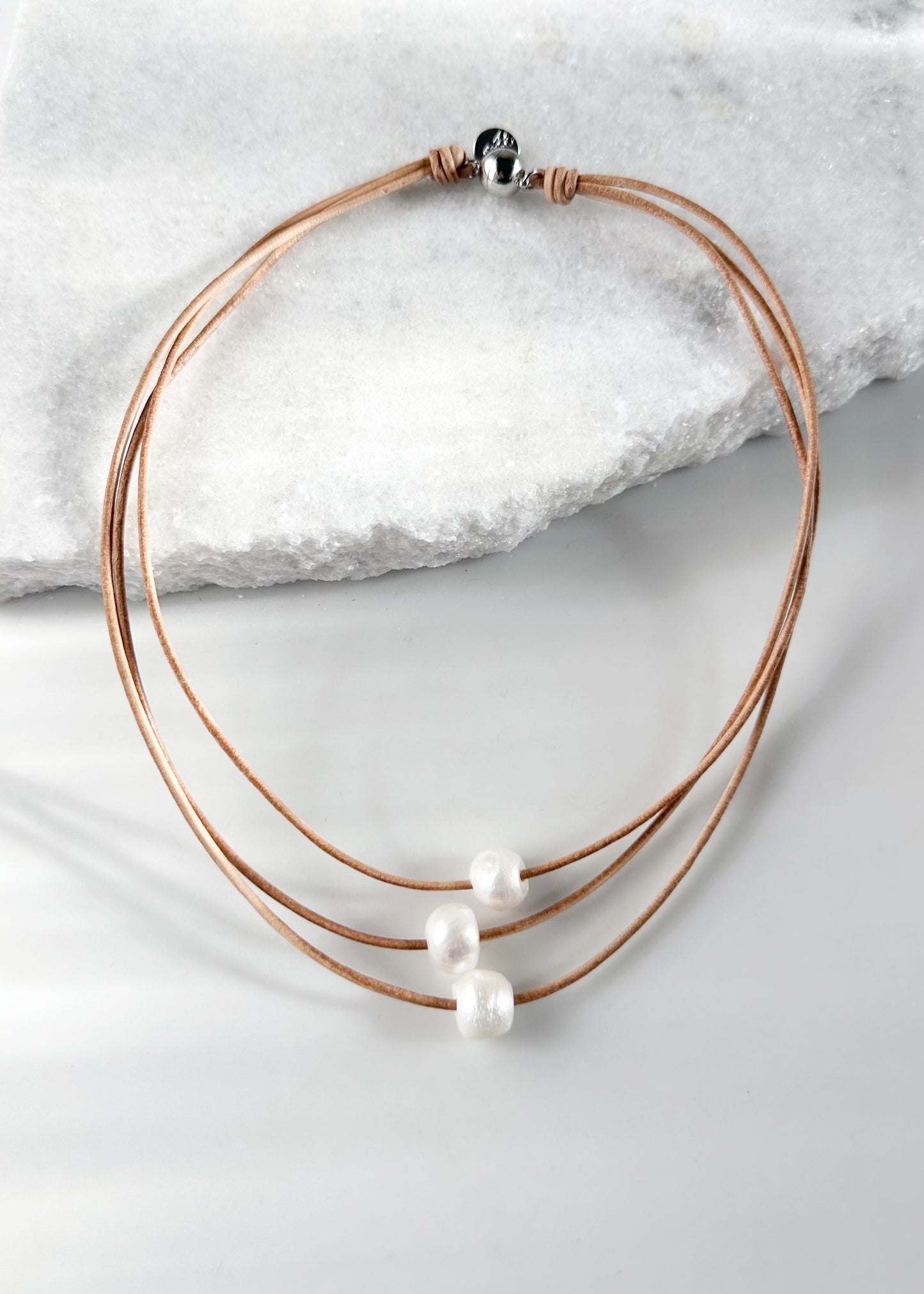 Designed in Canada, the Lane Necklace has Three Graduated Strands of Leather with Three Floating Pearls. The Shortest Strand is 17", the Longest is 18.5". This pretty necklace is light and easy on with a Magnetic Clasp.
