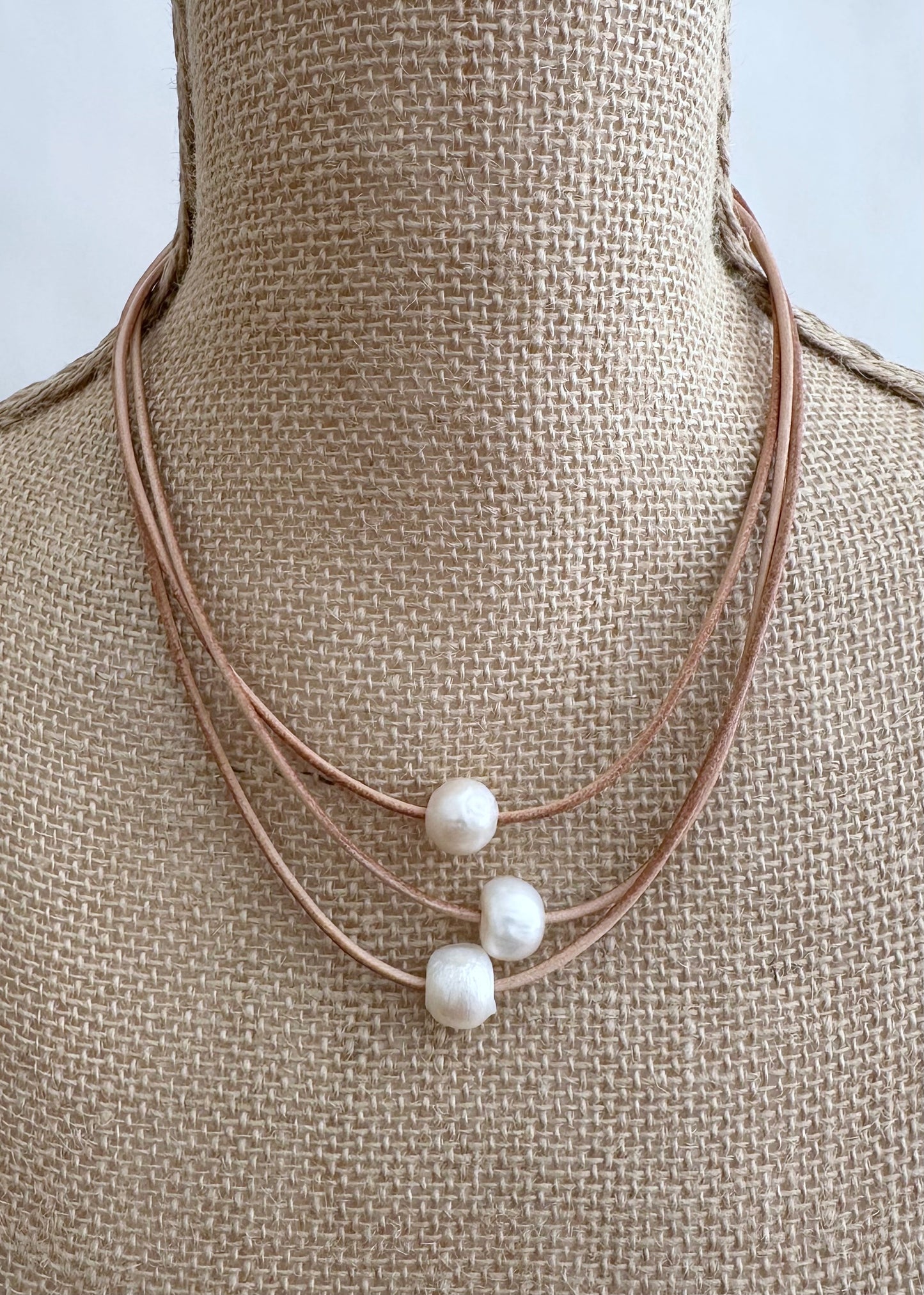 Designed in Canada, the Lane Necklace has Three Graduated Strands of Leather with Three Floating Pearls. The Shortest Strand is 17", the Longest is 18.5". This pretty necklace is light and easy on with a Magnetic Clasp.