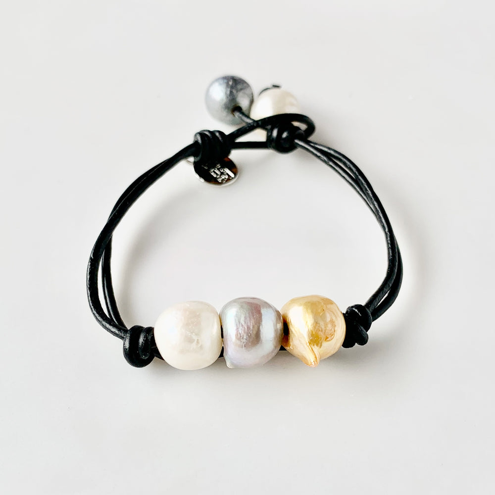 Black Leather Bracelet Highlighting Three Mixed-Color Baroque Freshwater Pearls with a Separate Pearl and Loop Closure. Can be worn Separately or Layered with other Bracelets.
